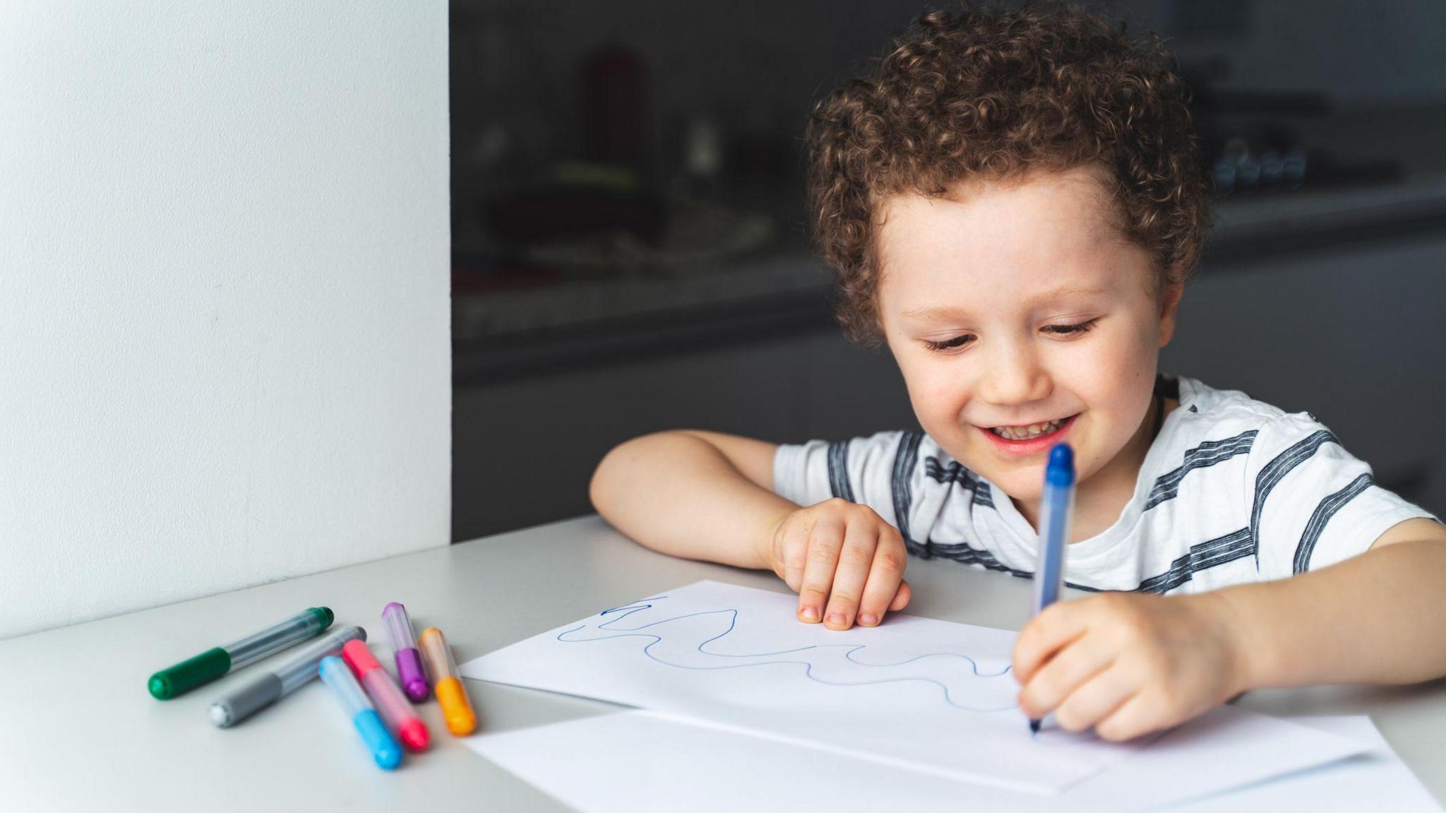 a child drawing with their left hand