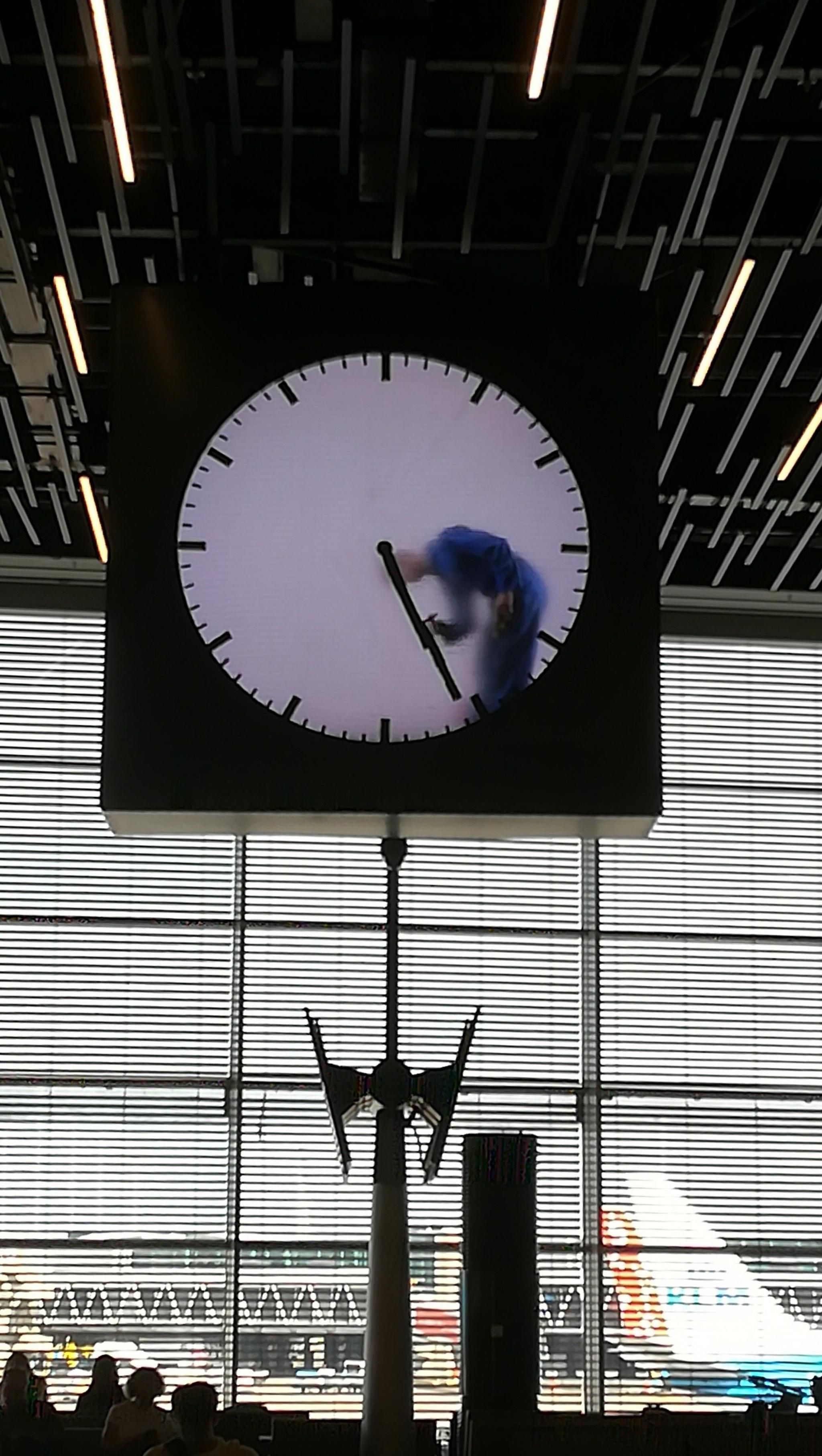 A person cleans the clock at Schiphol airport