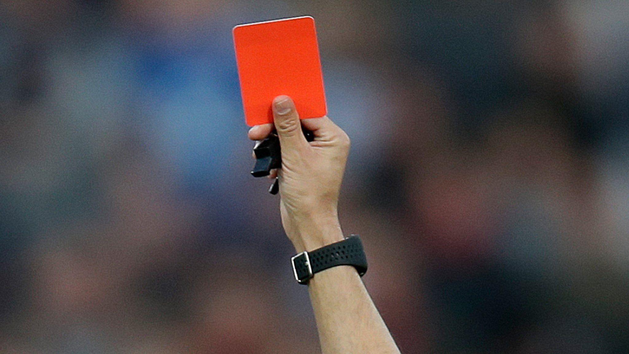 A red card is held up (stock image).