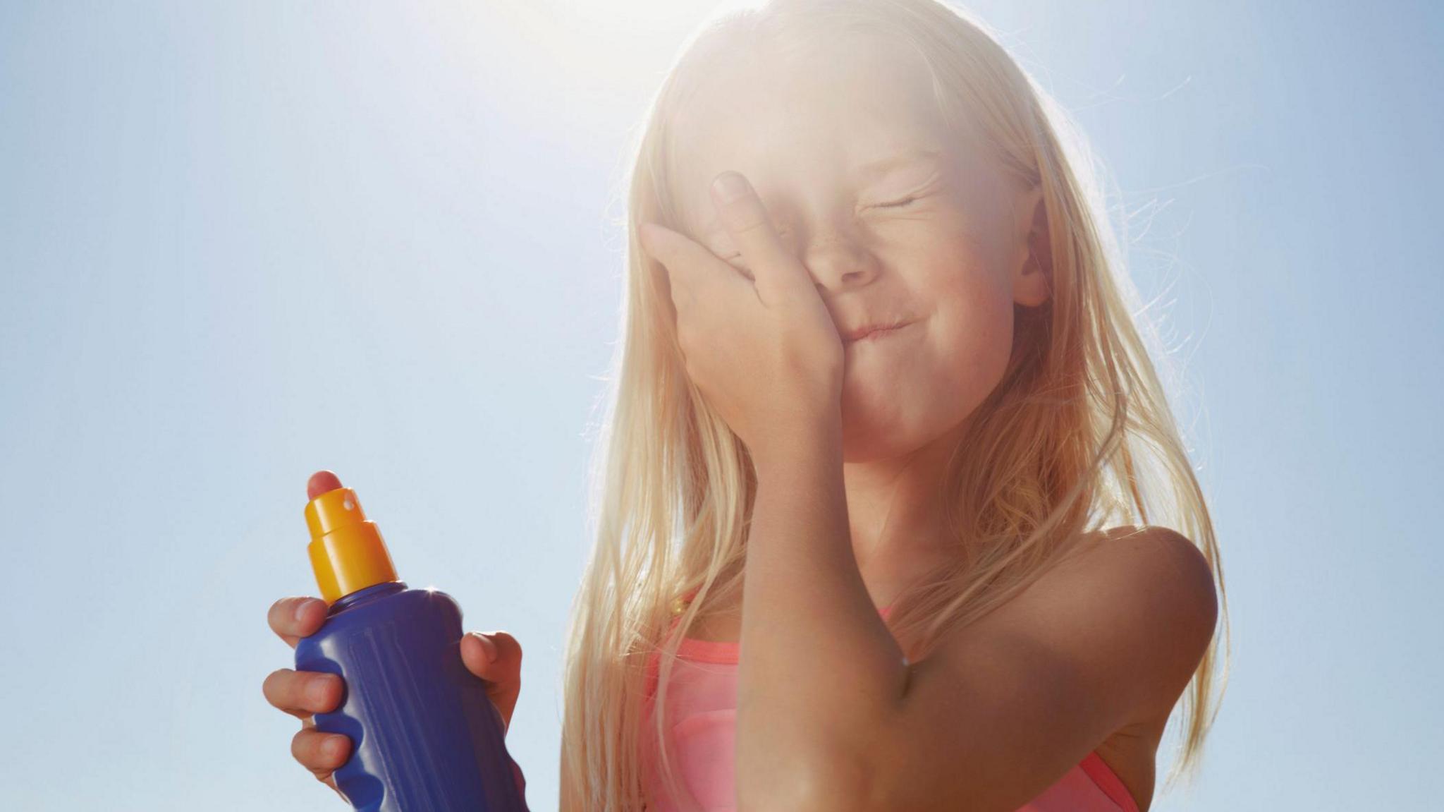 Girl putting suncream on