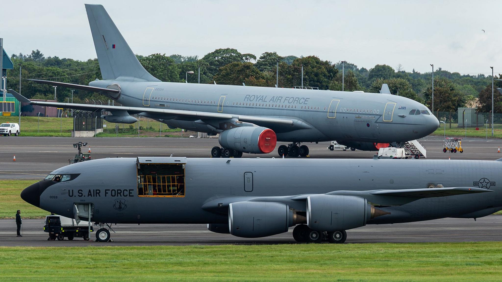 Two grey coloured military planes on a runway