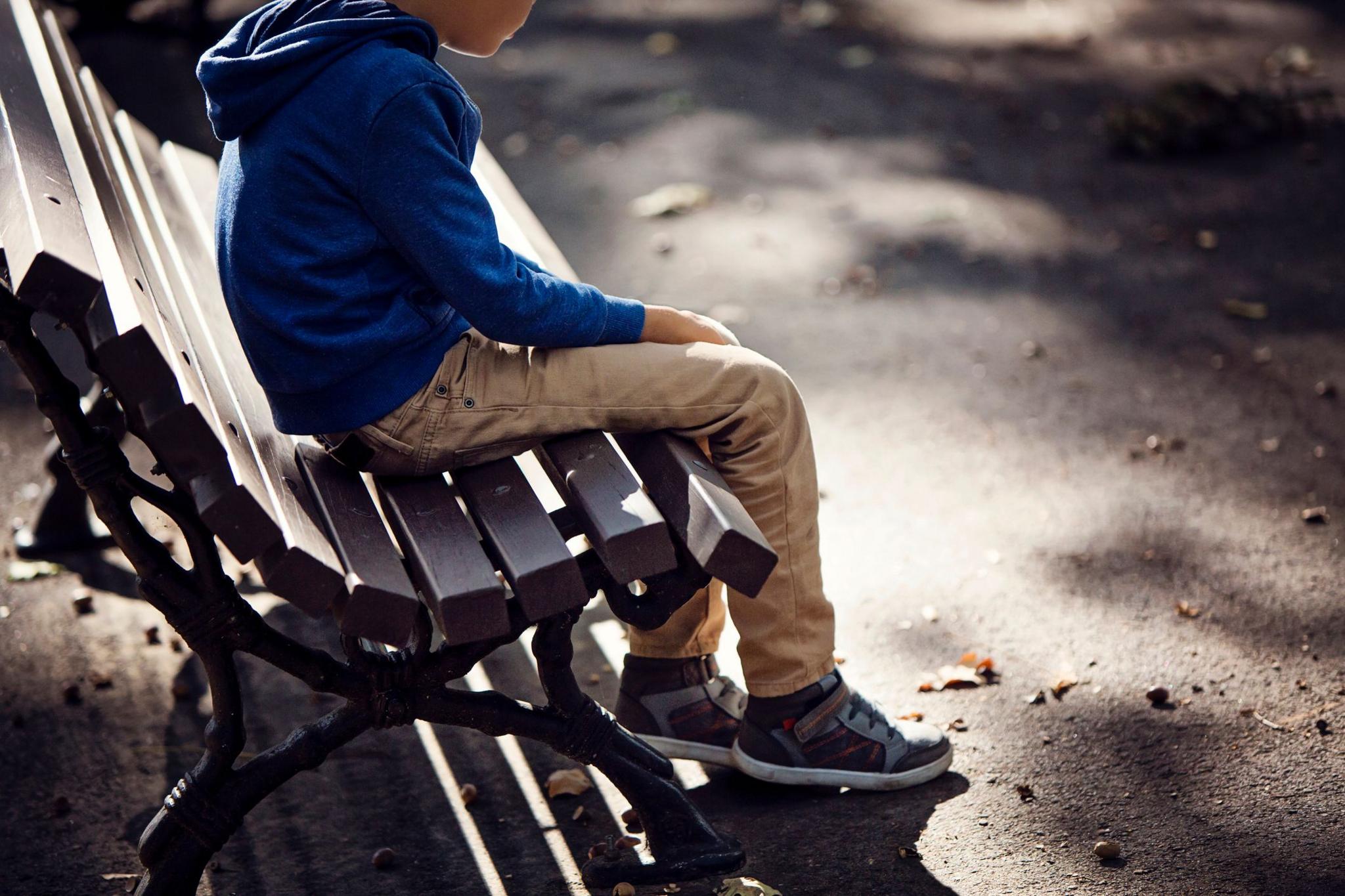 A boy sitting on a bench.