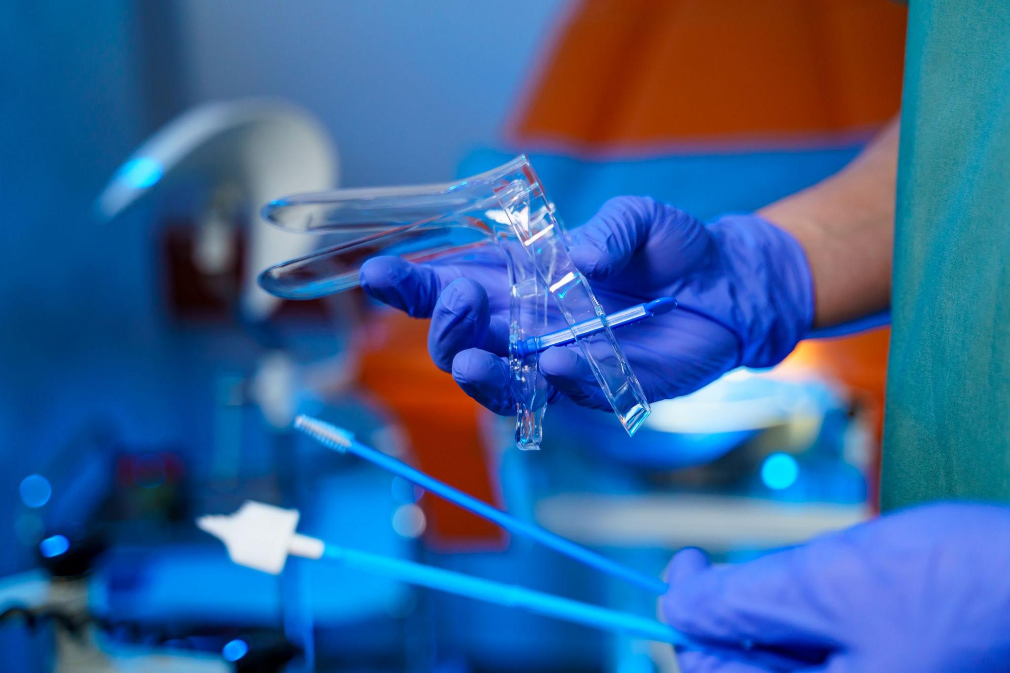 Medic holds a speculum used in a smear test 