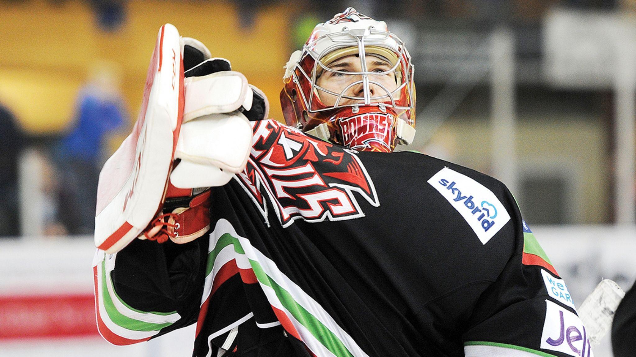 Ben Bowns in helmet pulls on the Devils logo of his black jersey with his gloved hand