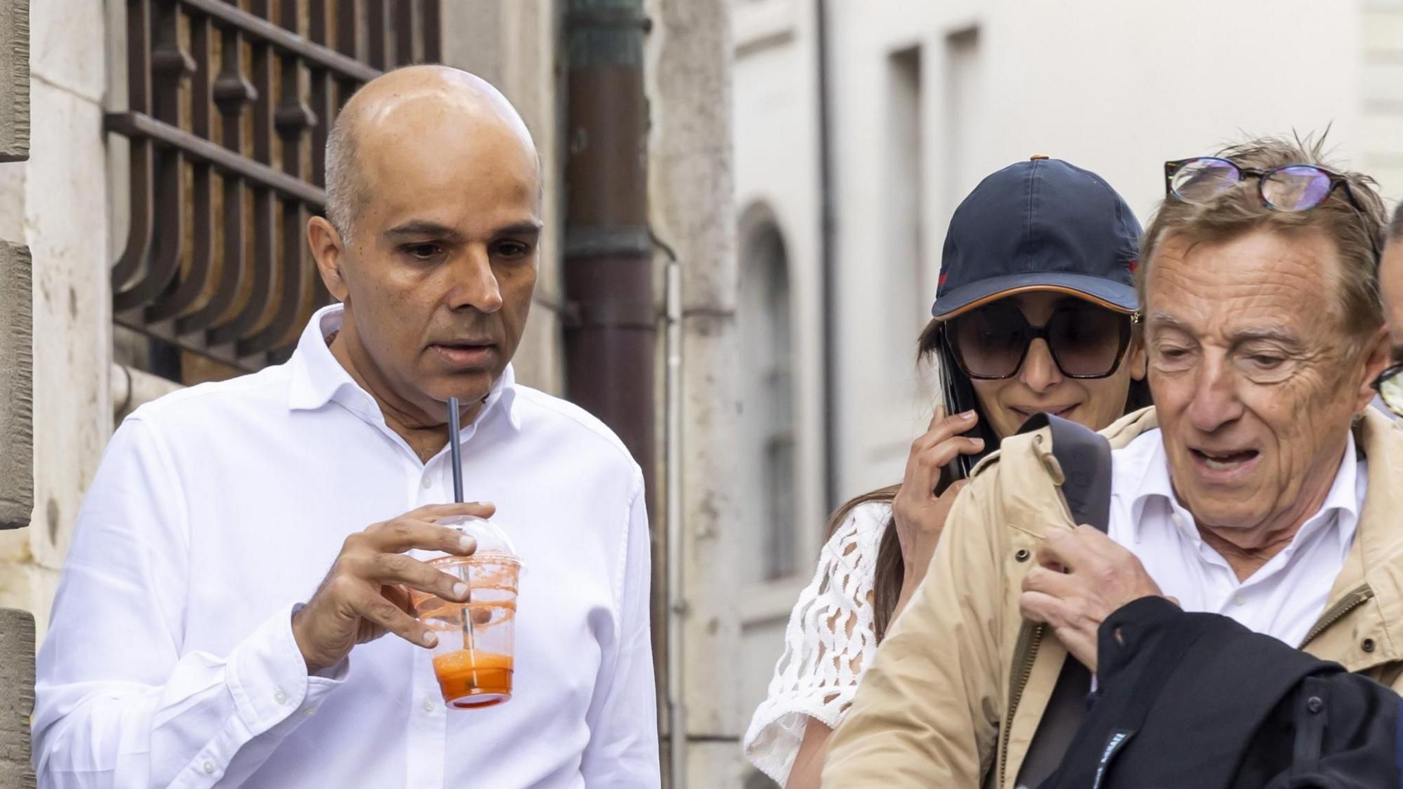 Ajay Hinduja and his wife Namrata walking with  lawyer Robert Assael