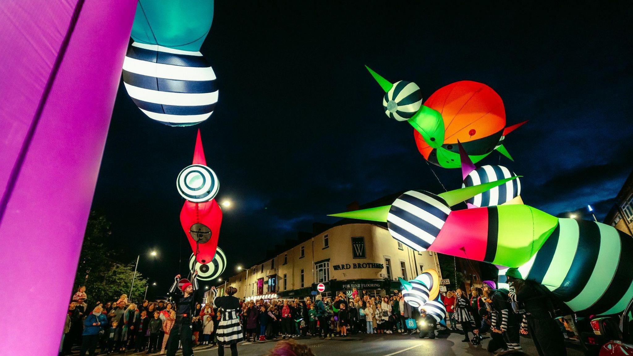 Giant colourful puppets in the dark on the street