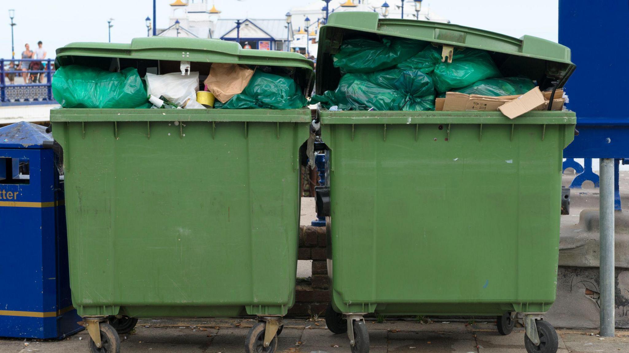 Two large wheelie bins with rubbish inside 