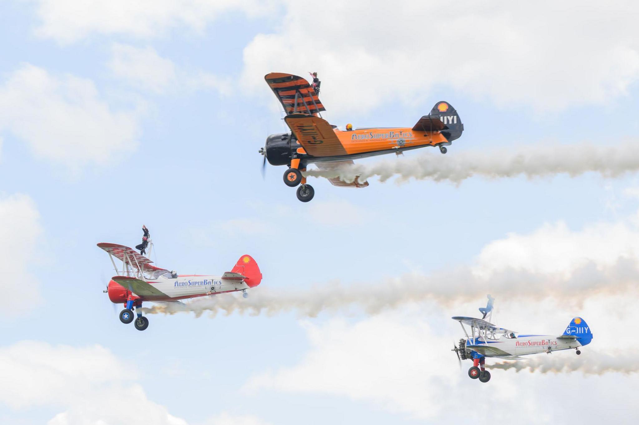 Three bi-planes in flight with wing walkers Flame Brewer, 21, Rose Powell, 20, and Jasmine Norman, 20 on the top deck of each aircraft.