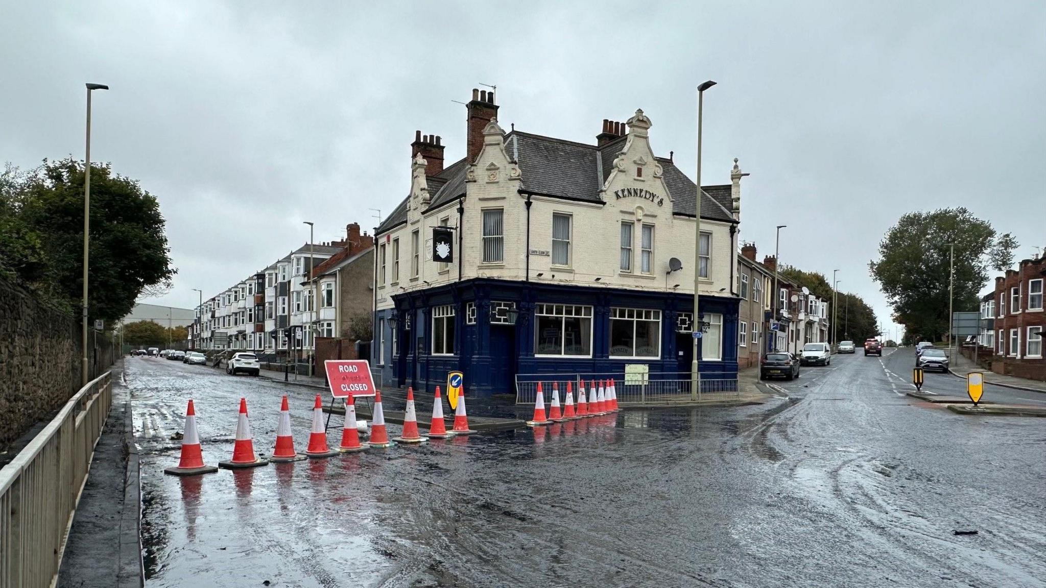 South Eldon Street. There is a line of red and white cones with Road Closed sign next to a two-storey pub called Kennedy's. 