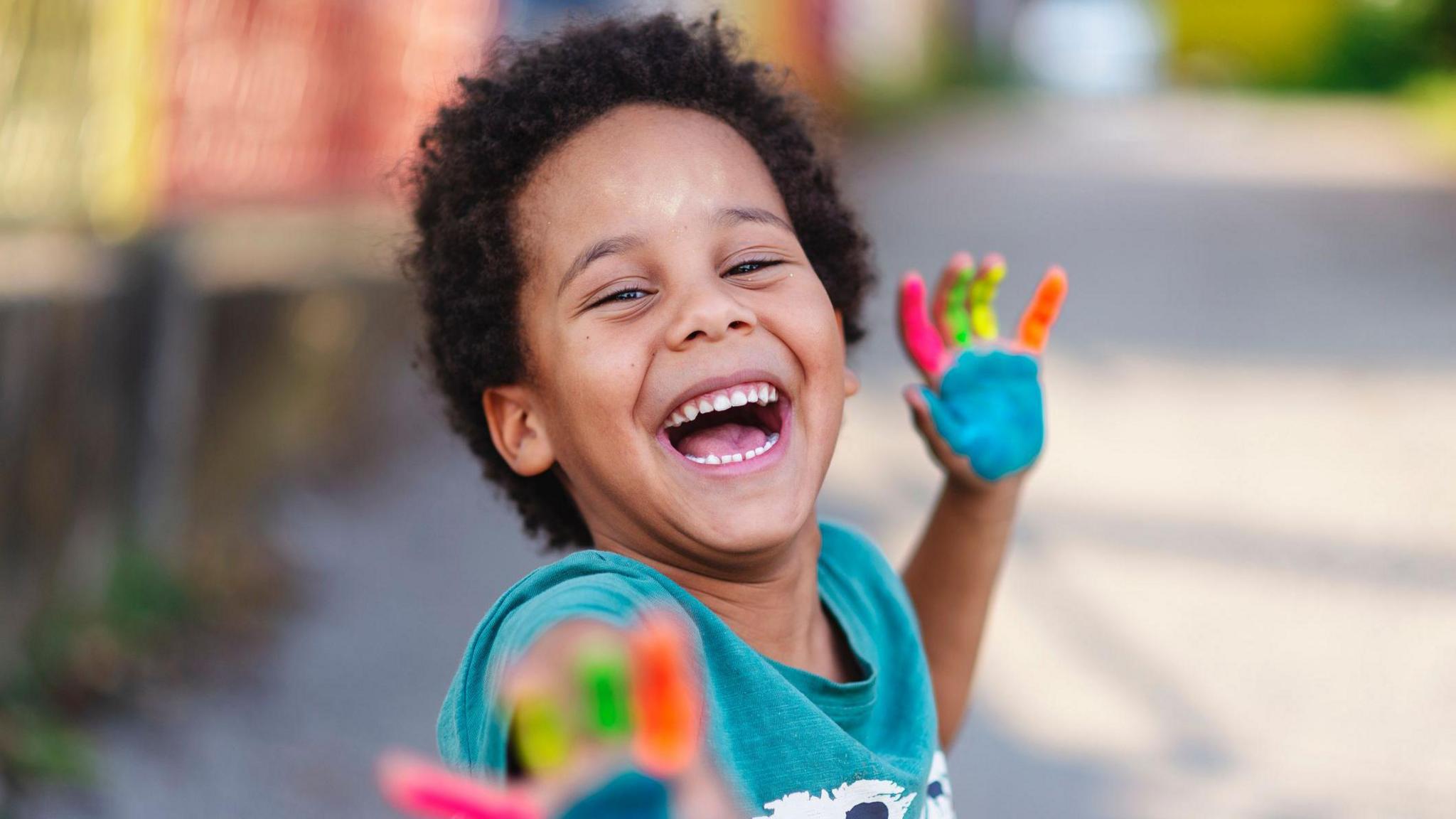 smiling boy with painted hands. 