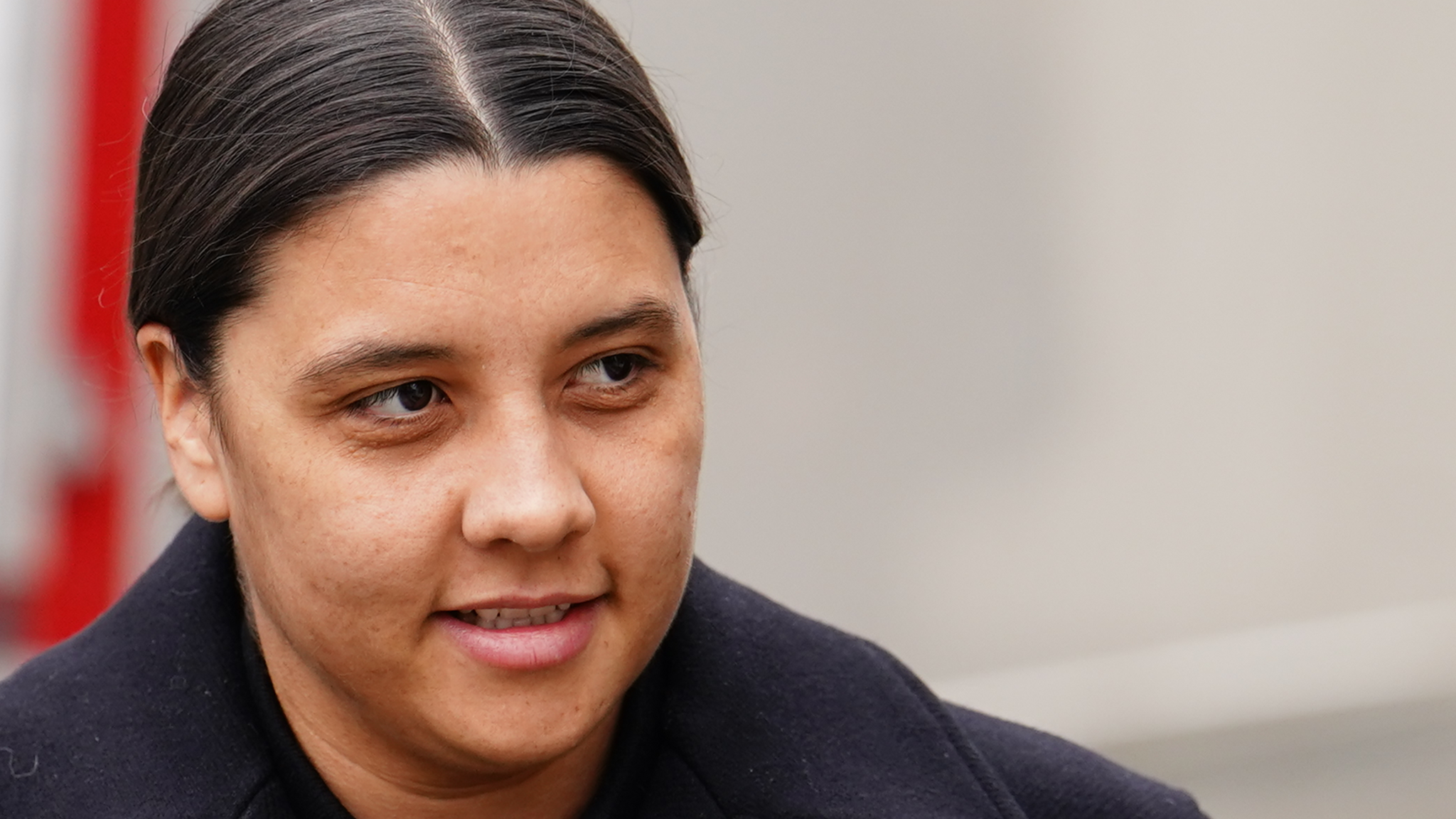 Samantha Kerr on her approach to court. She is wearing a dark winter coat and has her dark hair tied back