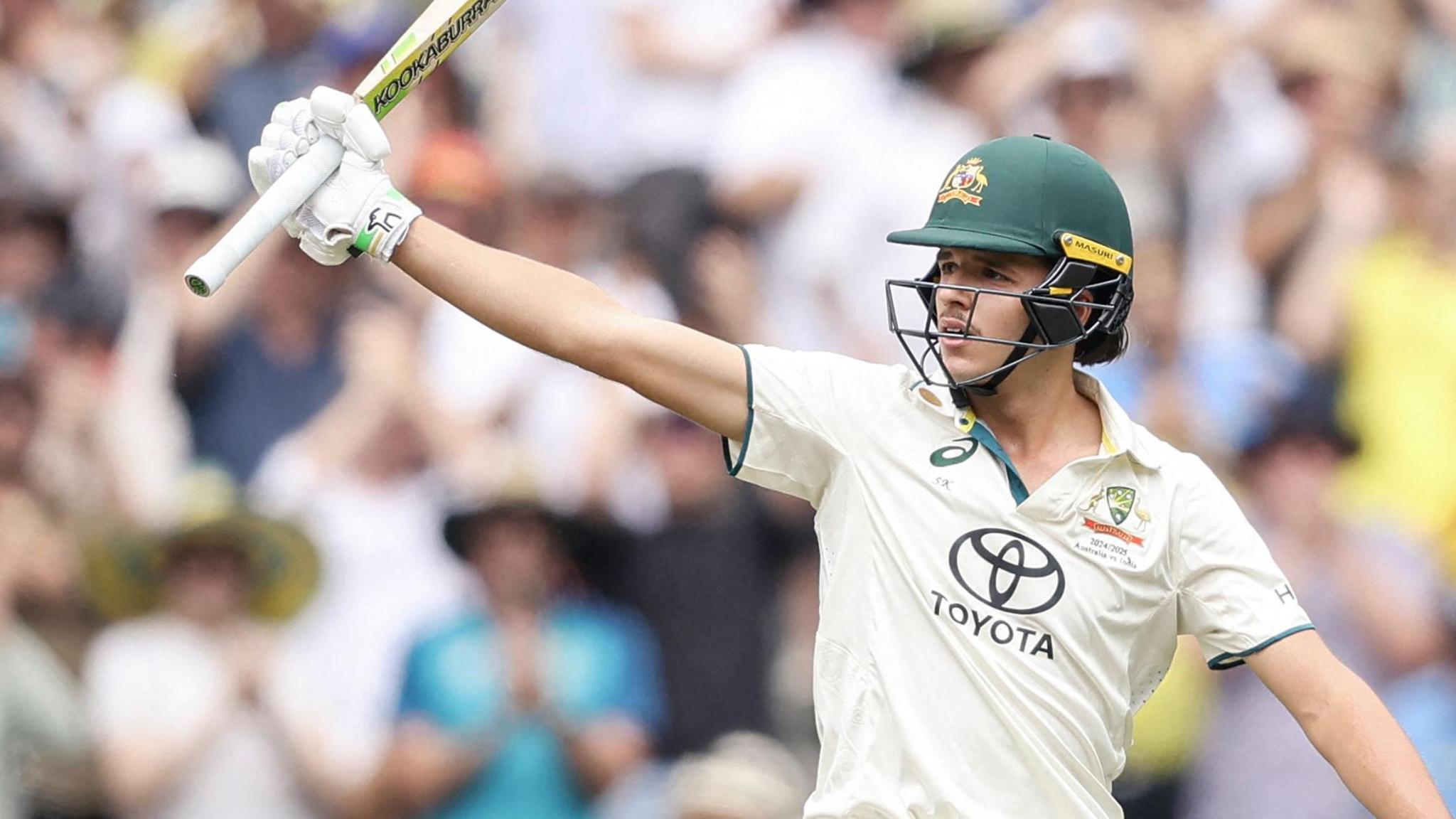  Sam Konstas raising his bat after hitting a half-century