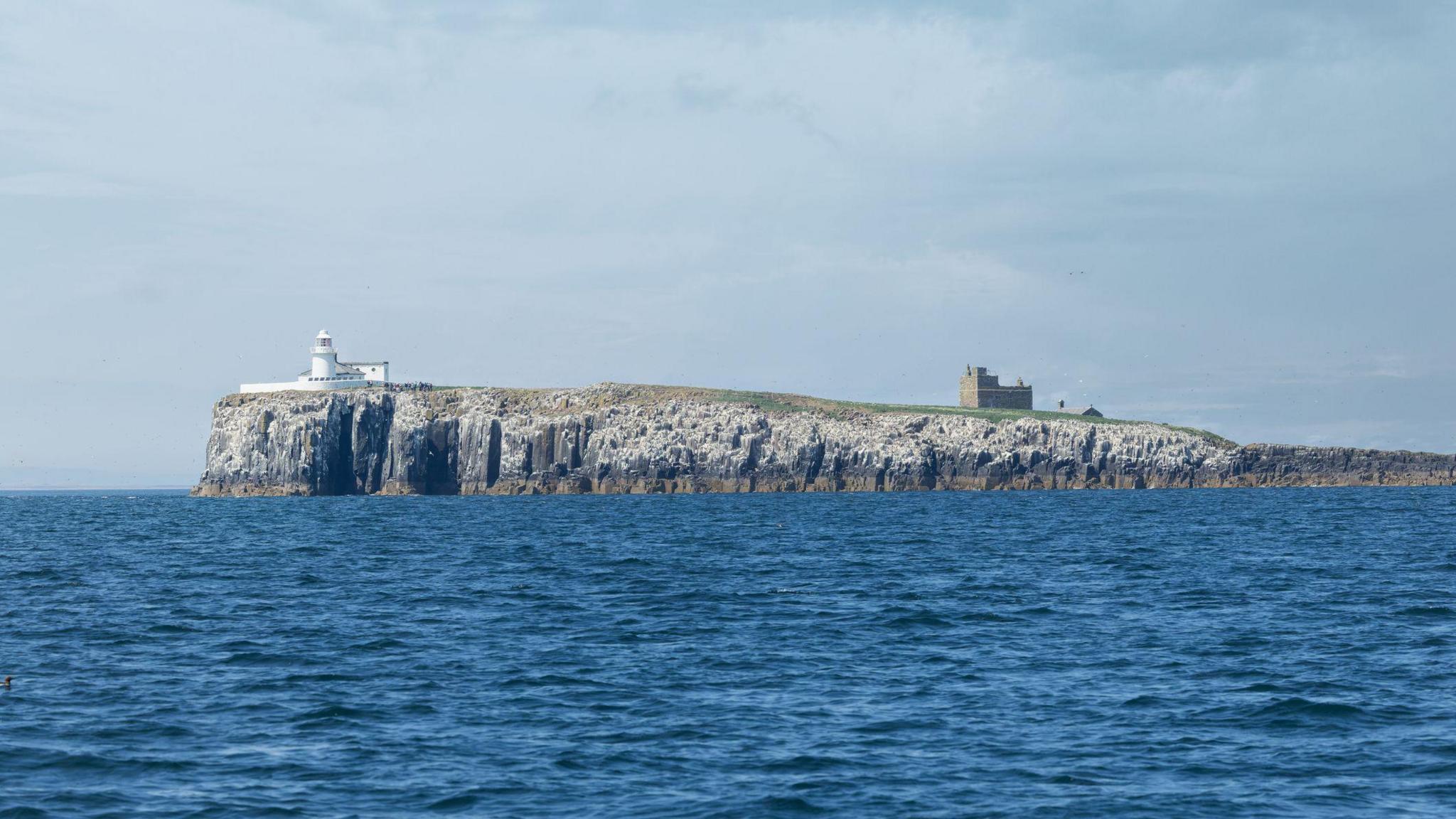 The Inner Farne Lighthouse and St. Cuthbert's Chapel on Inner Farne. Farne Islands, Northumberland Coast, England.
