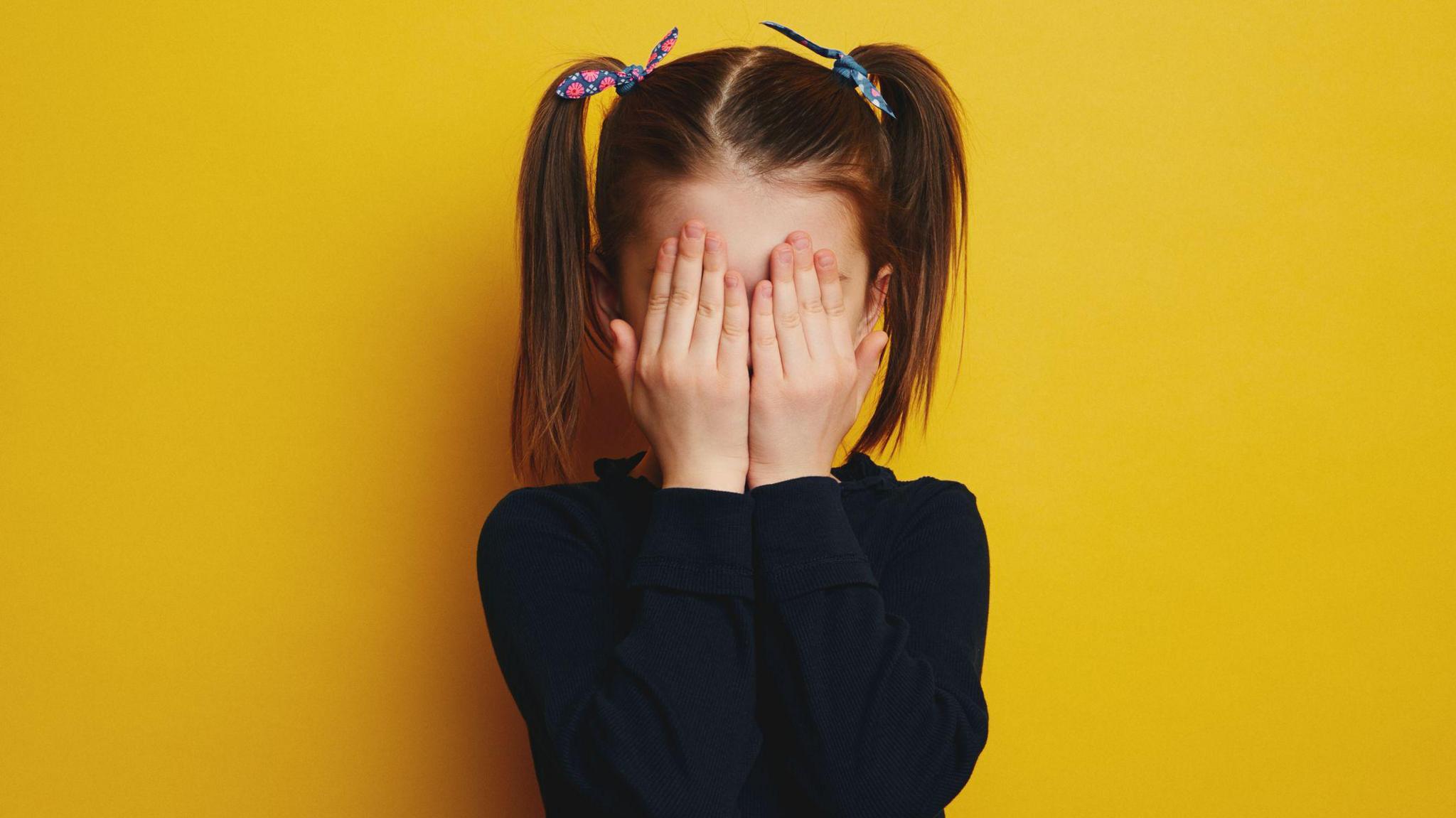 girl embarrassed on yellow background