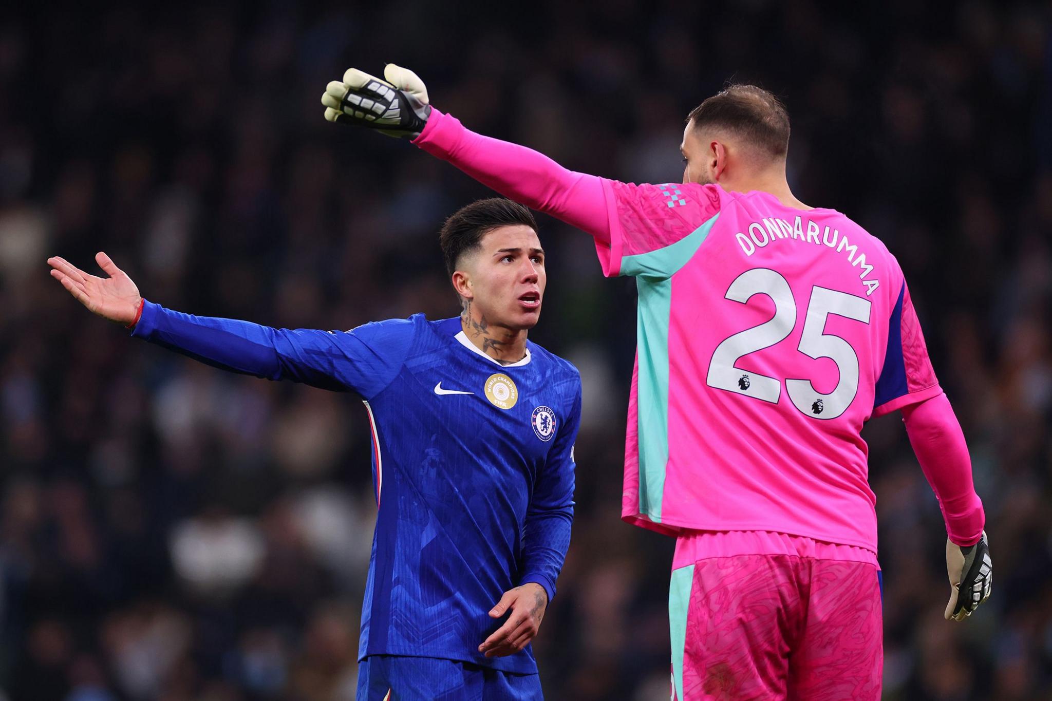 Chelsea's Enzo Fernandez confronts Manchester City's Gianluigi Donnarumma. Both have an arm outstretched. Photo by Marc Atkins