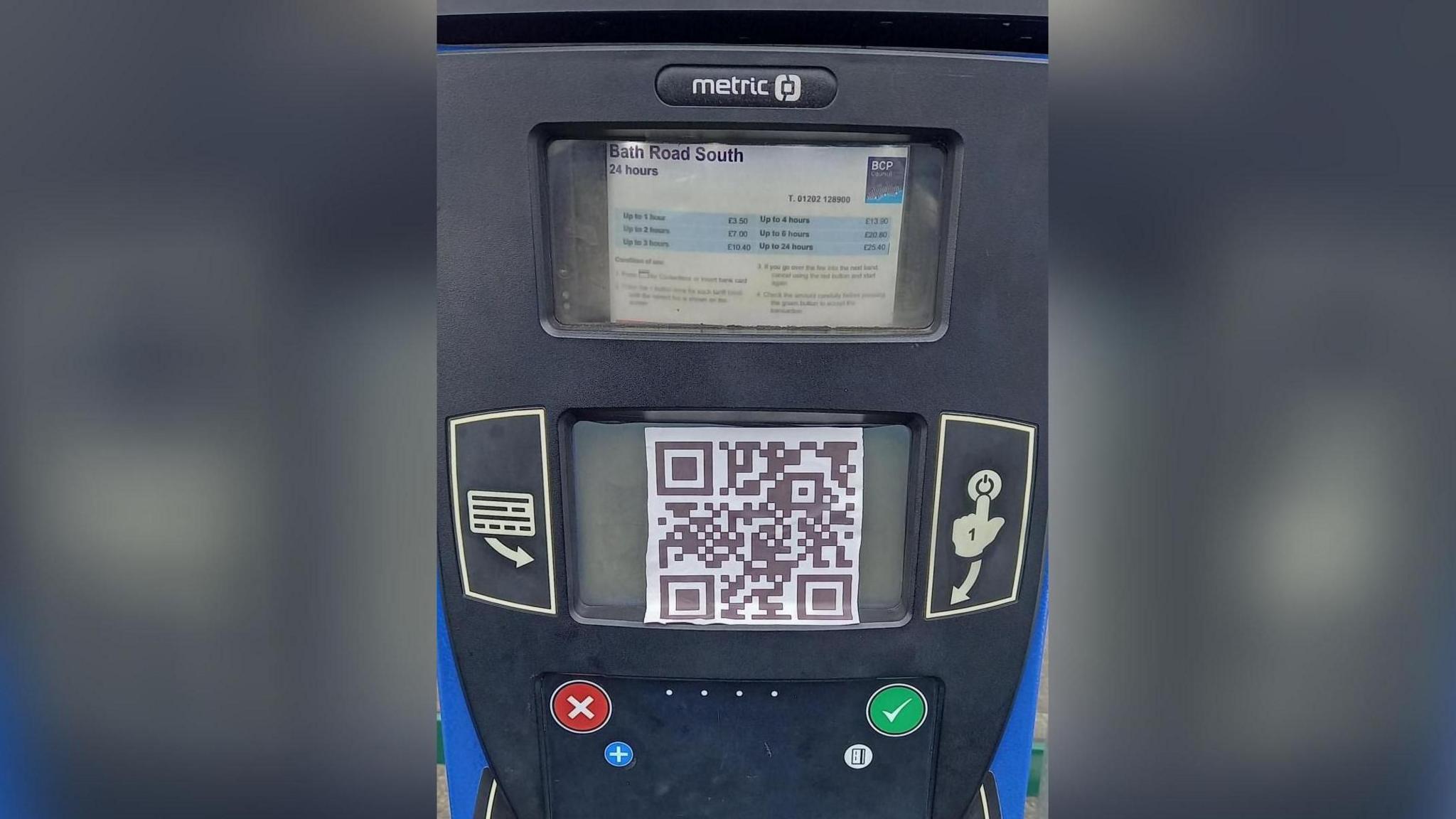 a parking machine with a large QR code stuck on it. The machine reads 'Bath Road South'.