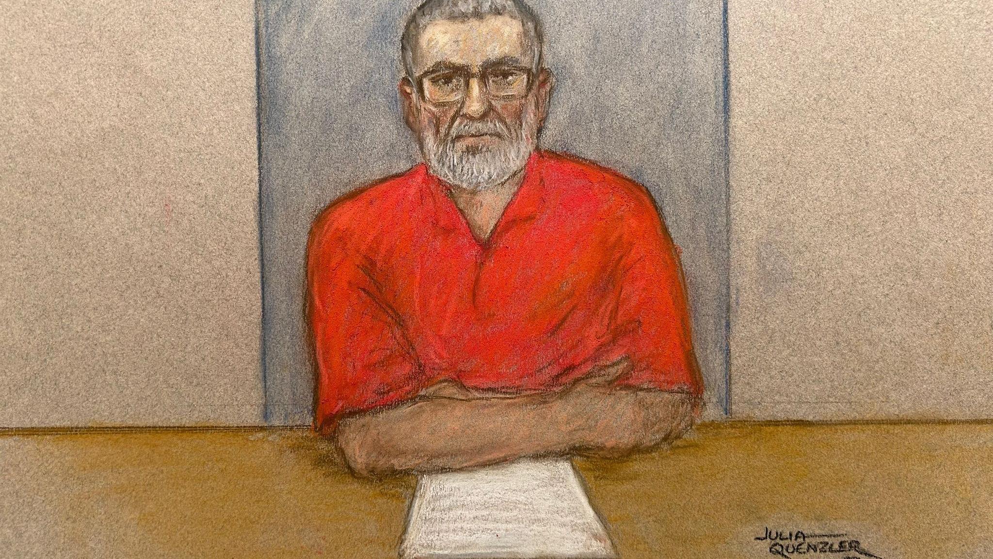 Court sketch showing a bearded Peter Sullivan, wearing a red open-necked shirt and glasses, sitting at a desk with some papers in front of him.