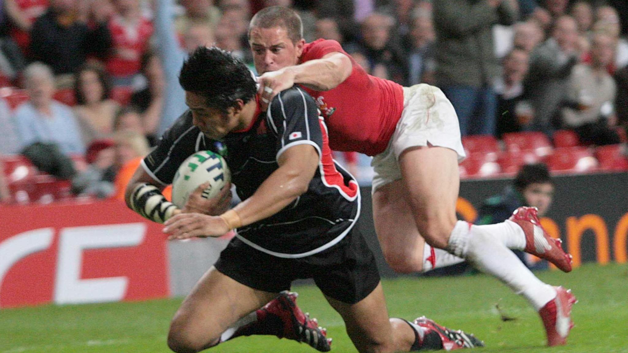 Kosuke Endo scores a try for Wales against Japan in 2007 despite Shane Williams' attempted tackle