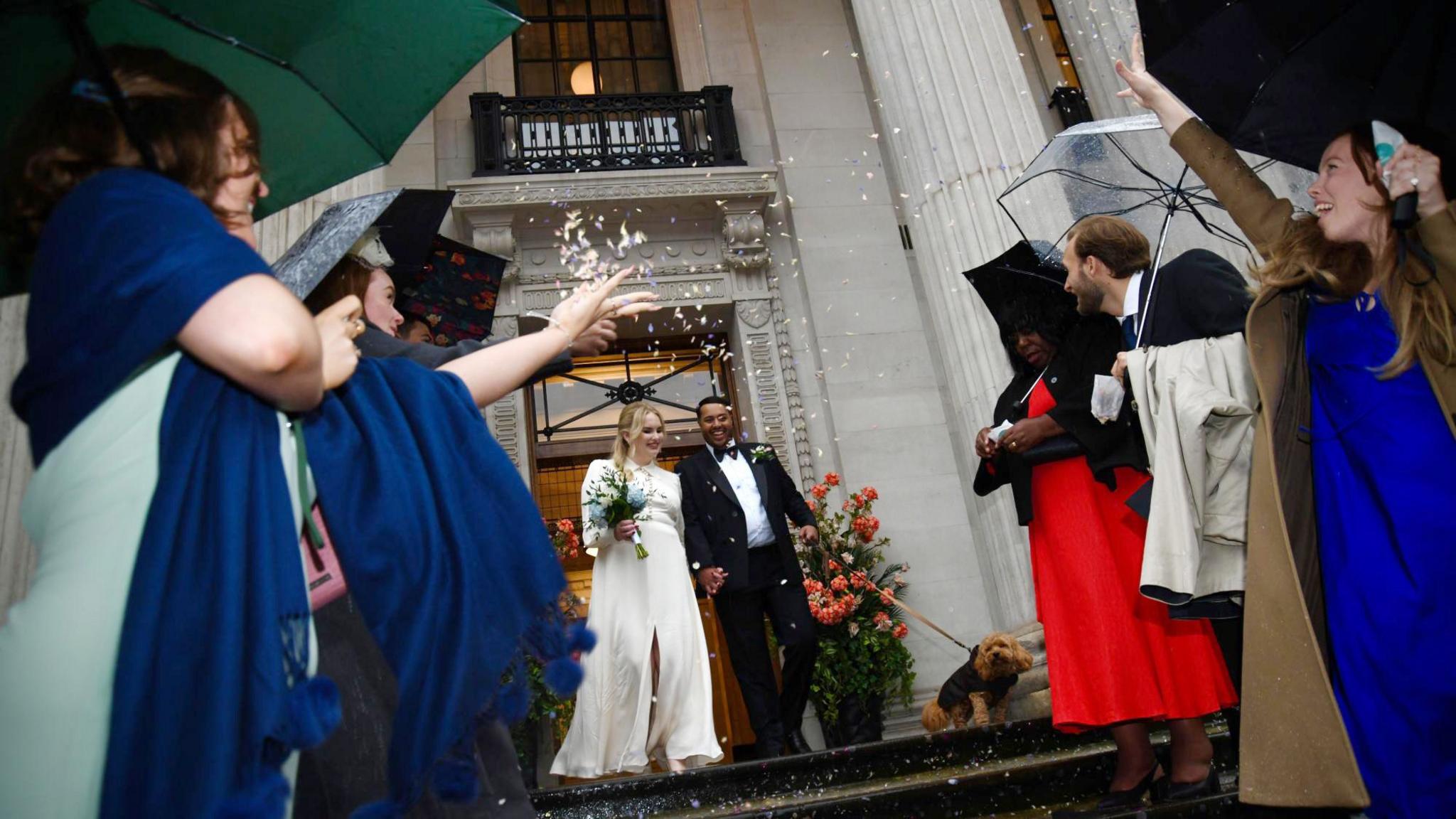 Daisy McDonnell and Dan McKinley with their dog Marvin leave the town hall