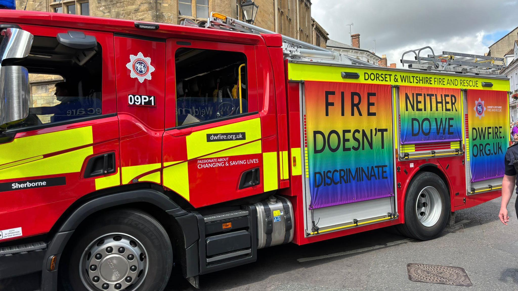 A Dorset Fire and Rescue Service fire engine adorned with Pride flags and inscription "Fire doesn't discriminate, neither do we".