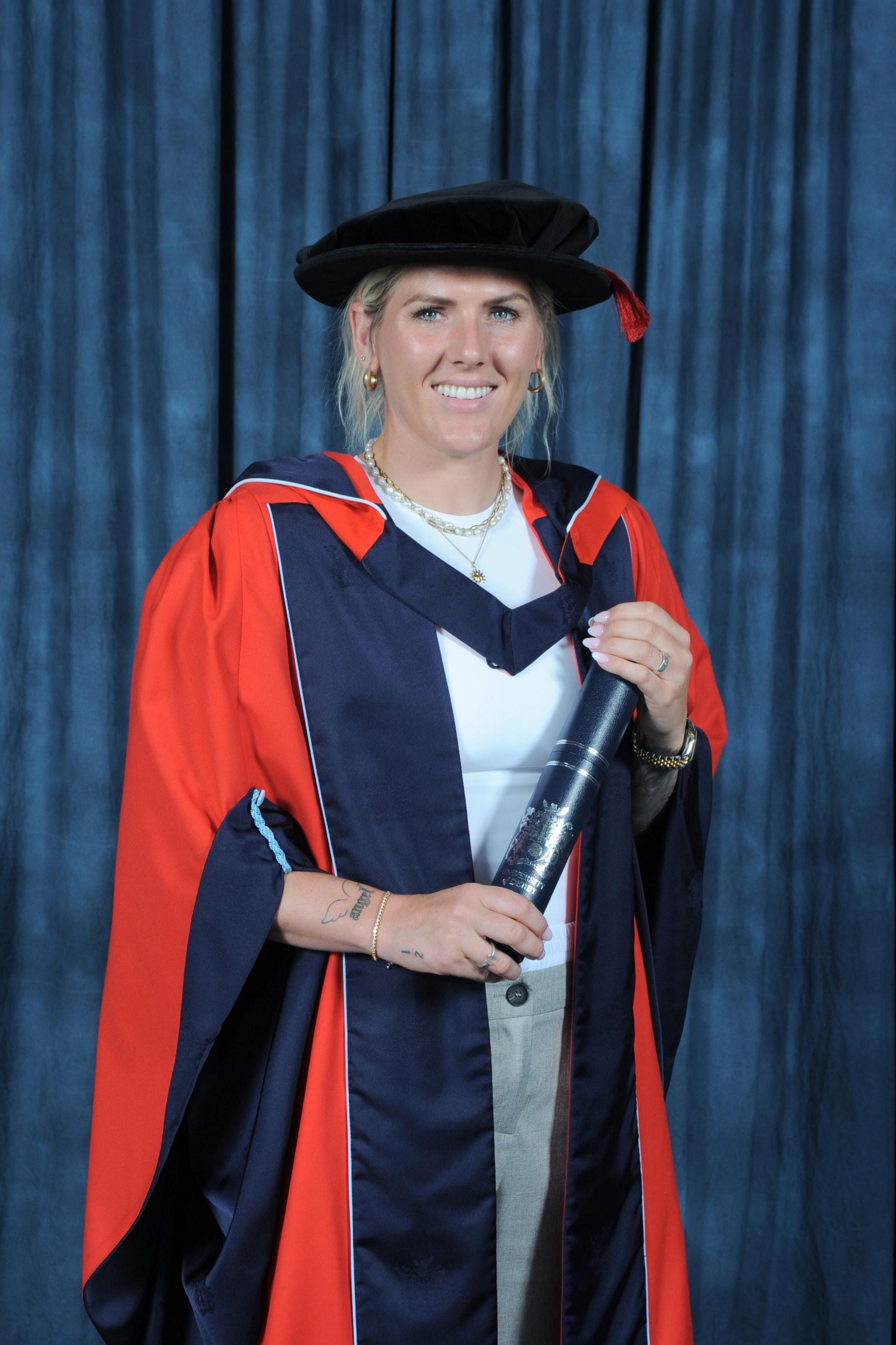 Millie Bright holding a scroll