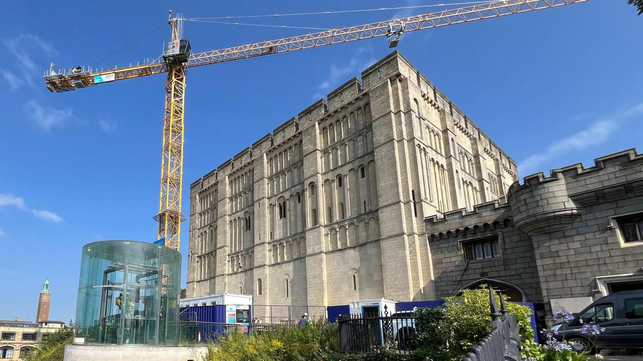 An exterior of Norwich Castle with a yellow crane located outside