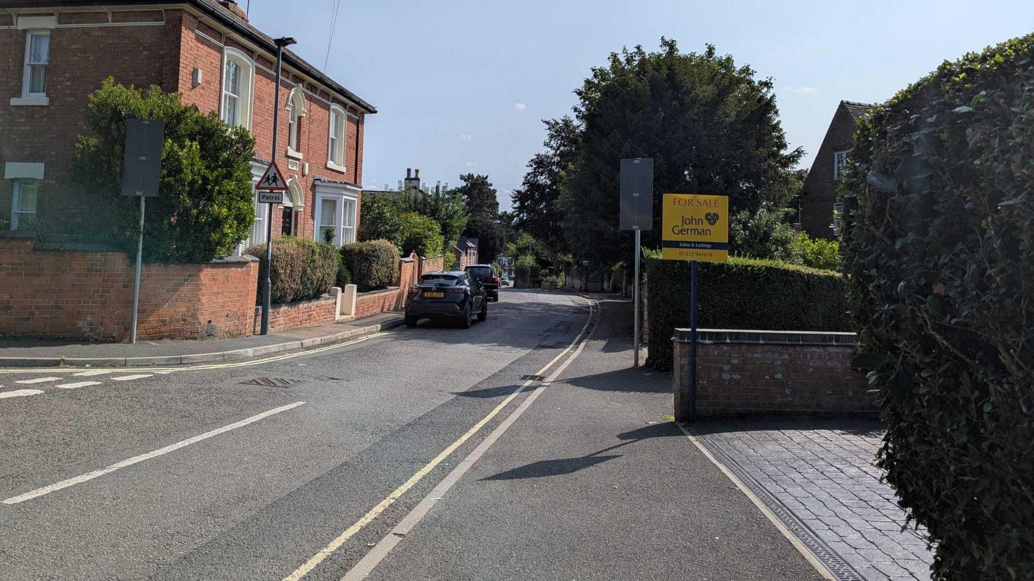 Church Street in Littleover. There is a single yellow line on the right hand side of the road.