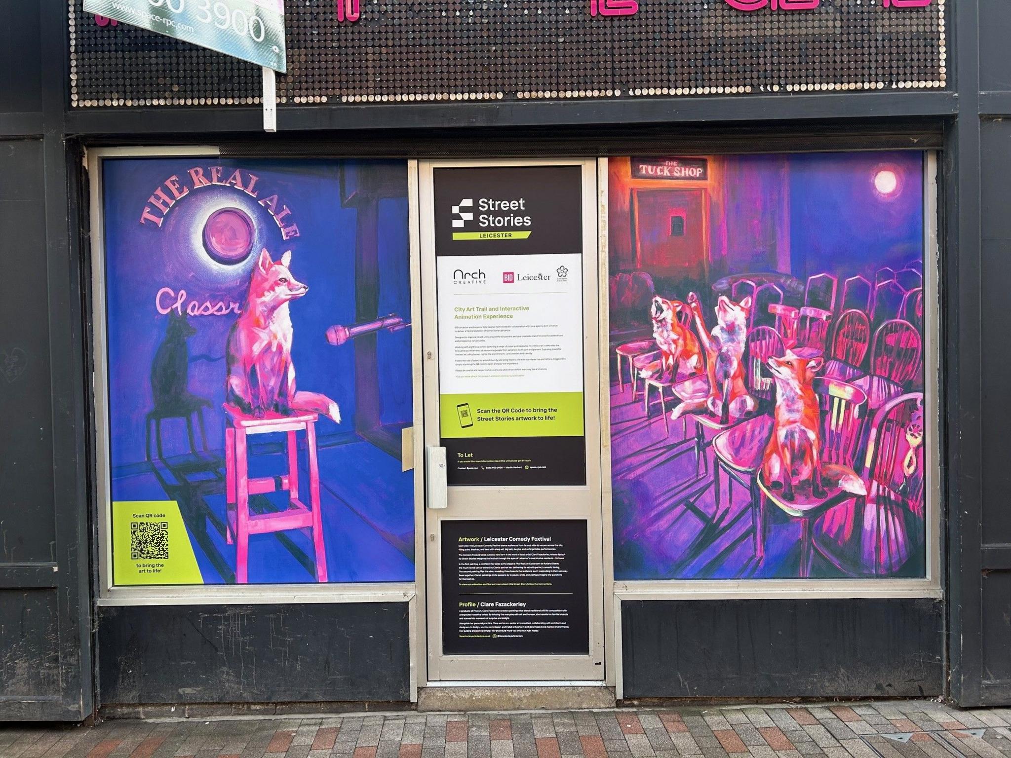 Artwork on a shopfront depicting a fox on a stool in front of a microphone, with several foxes sat on chairs in the audience.