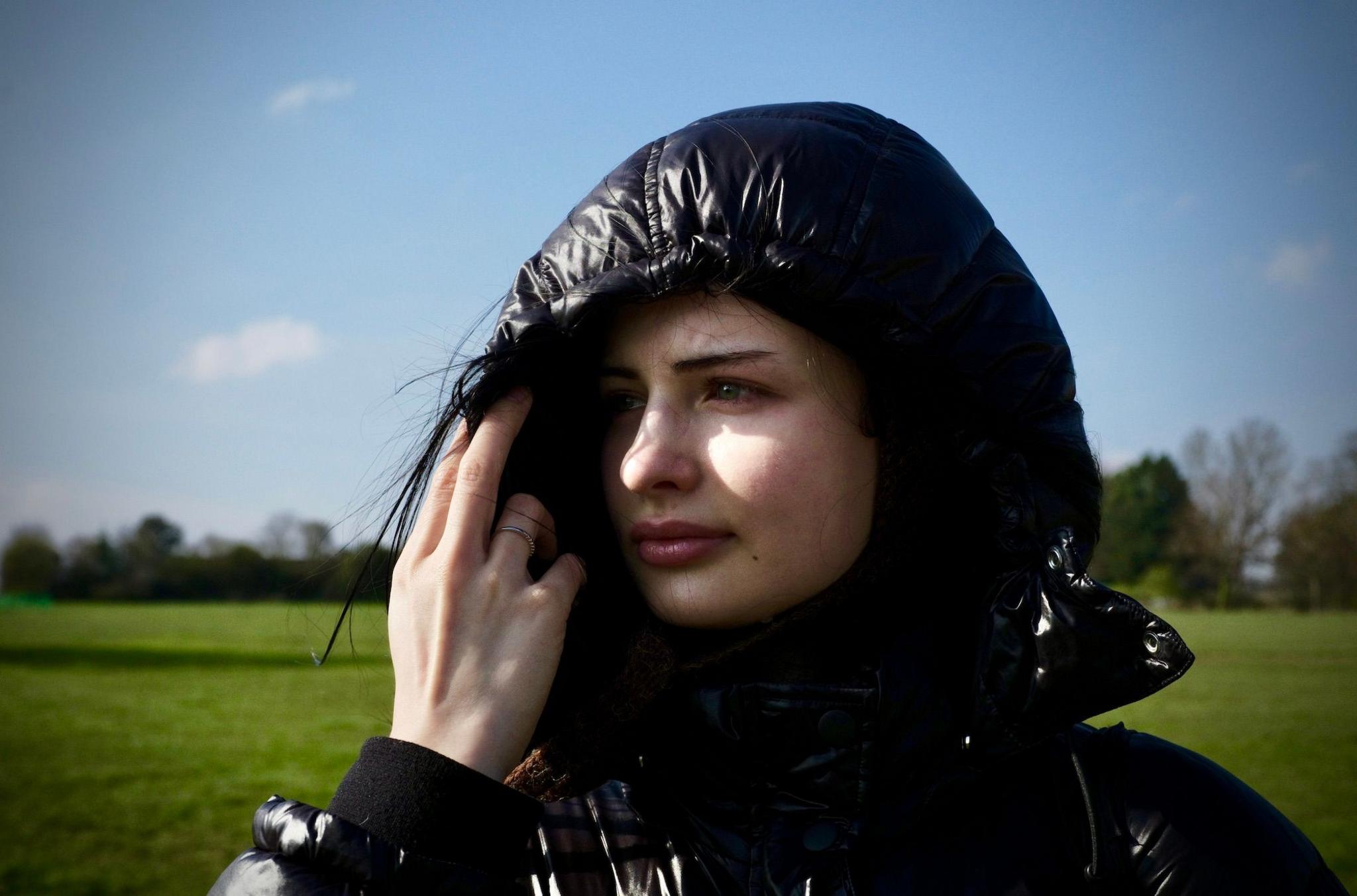 A woman in a hooded black coat