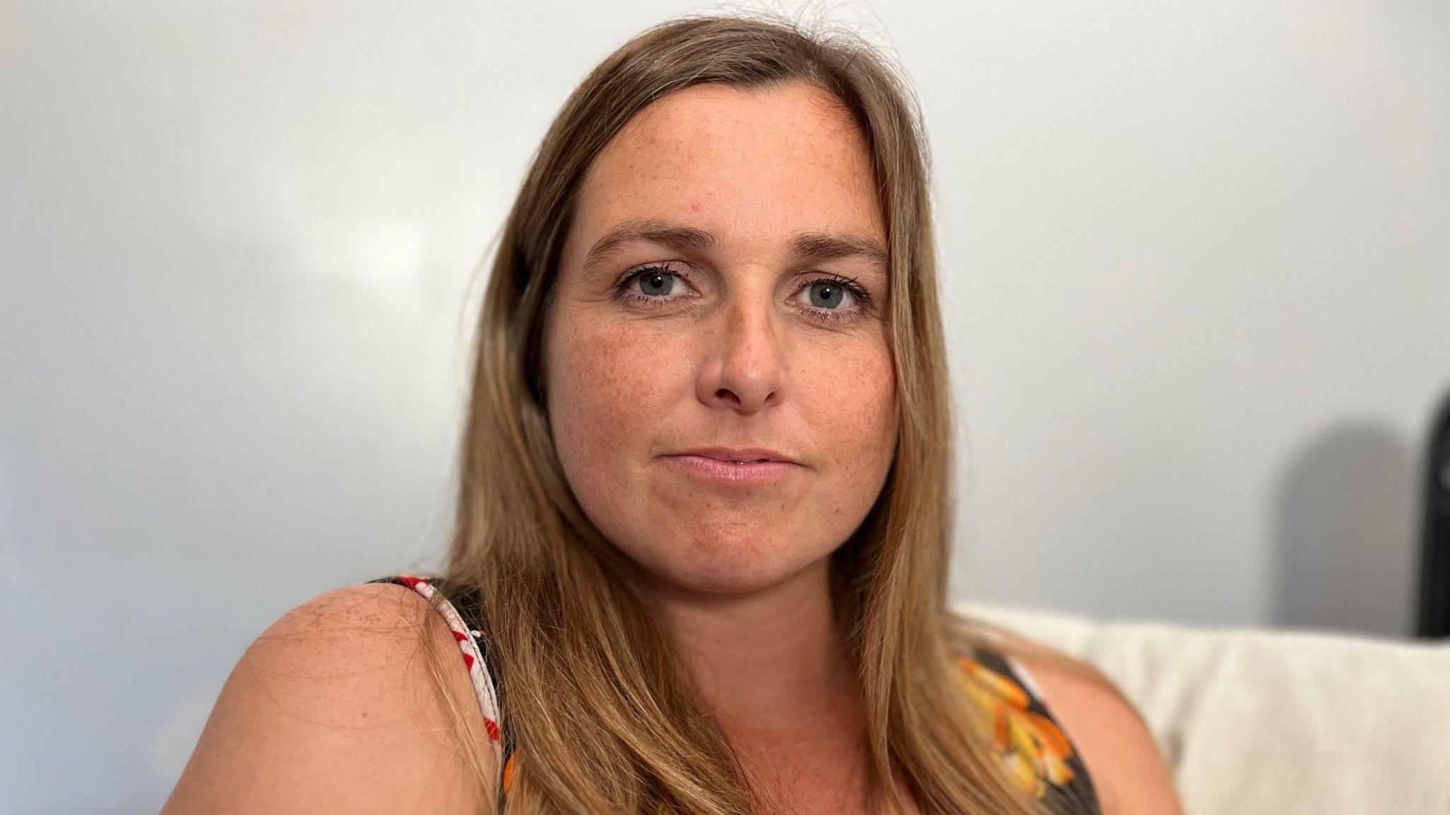 Becky Shone, modryb Ethan yn eistedd ar sofa yn ei thŷ
