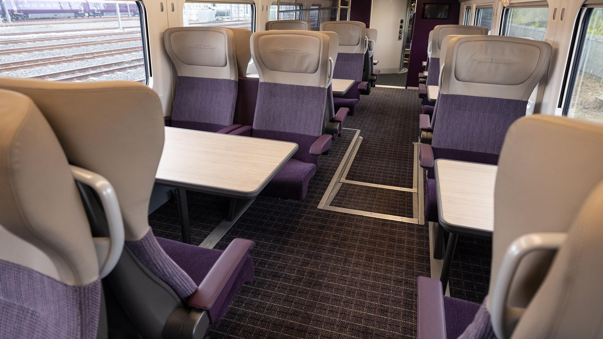 Interior of a first class carriage of a new train featuring purple and grey seats