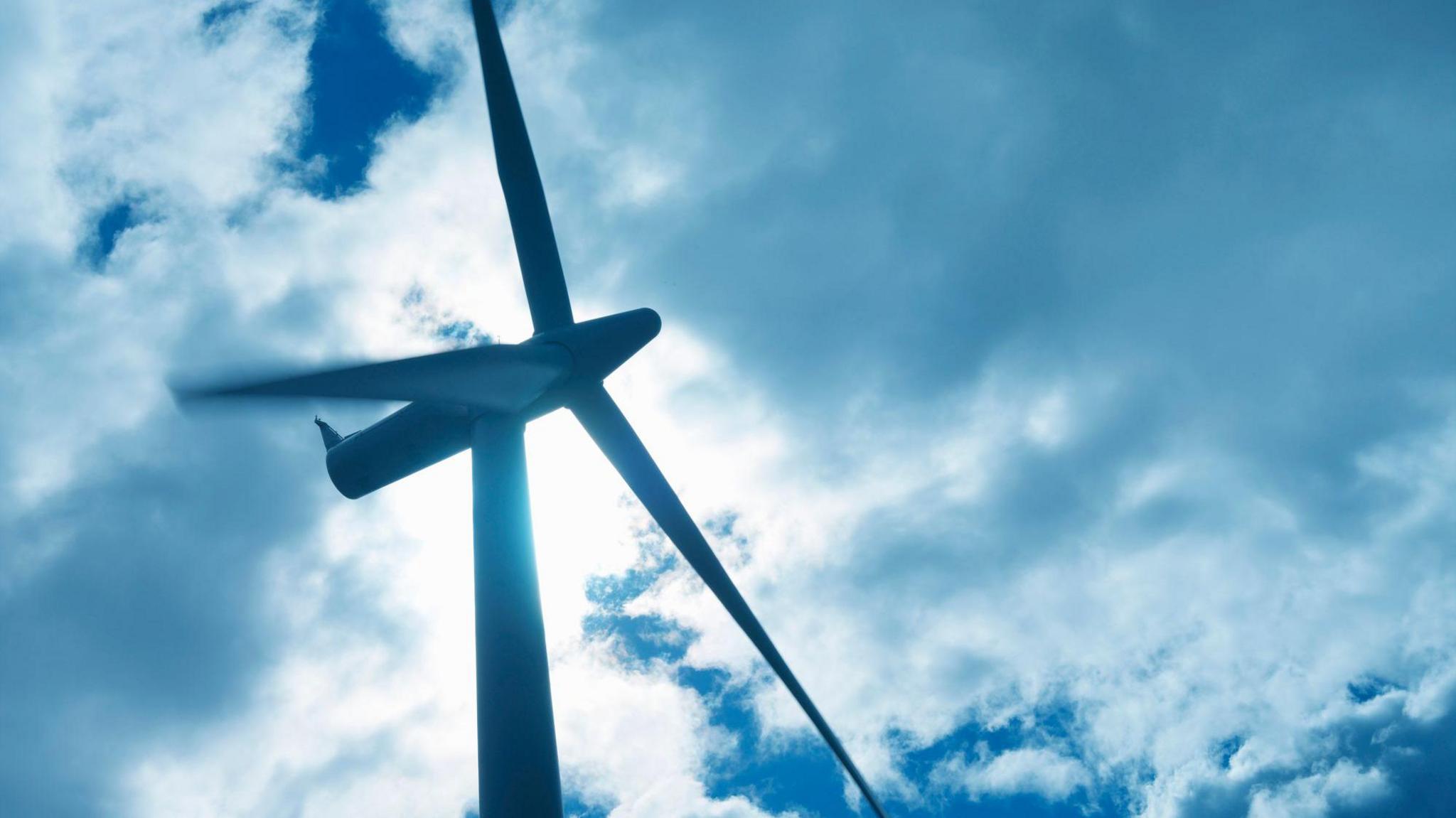 A wind turbine against a cloudy sky