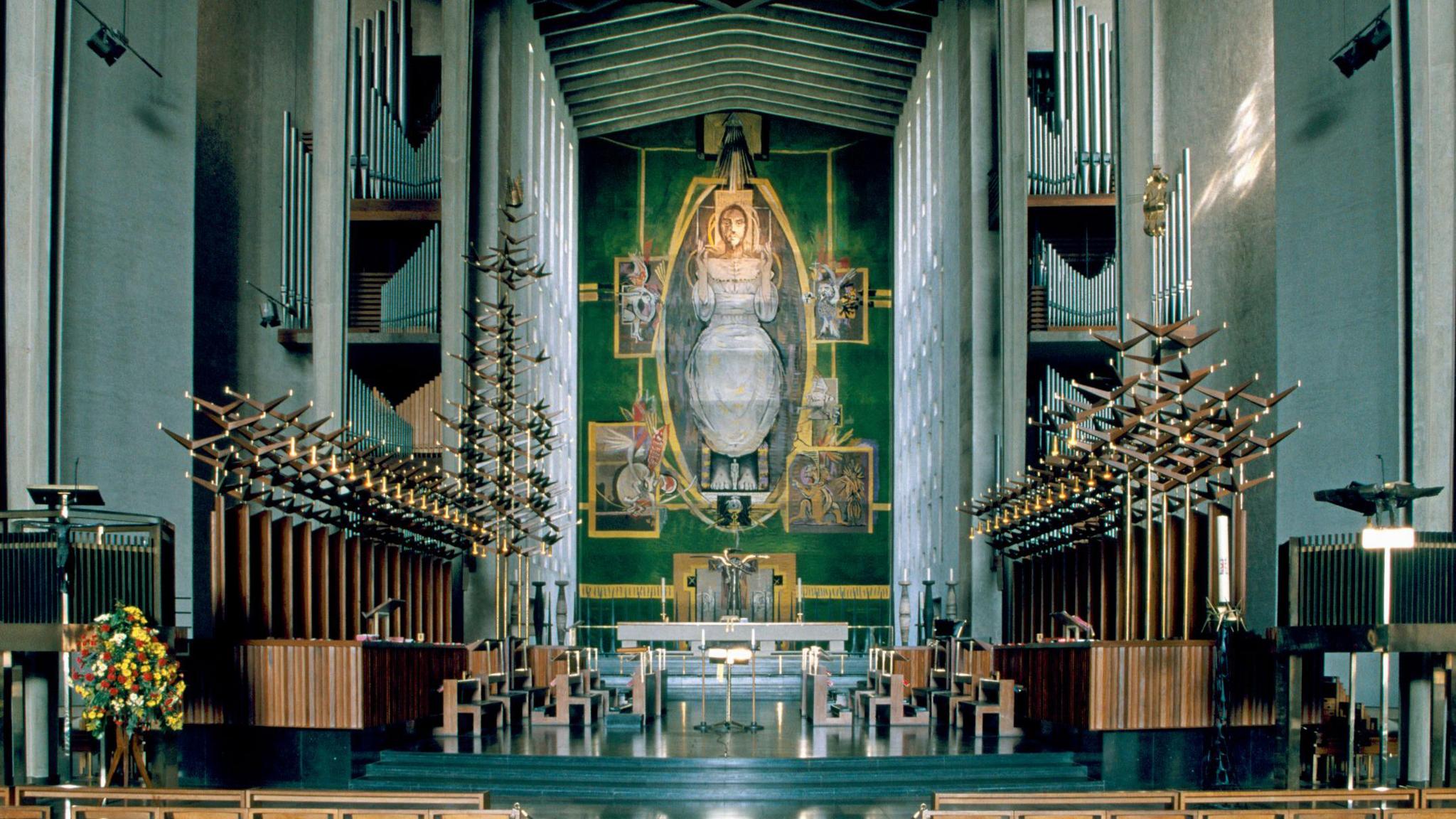 The nave of the cathedral, or the central part of the building, with a view of the tapestry, Christ in Glory, by Graham Sutherland, which depicts the risen Christ in an aura of light in heaven.