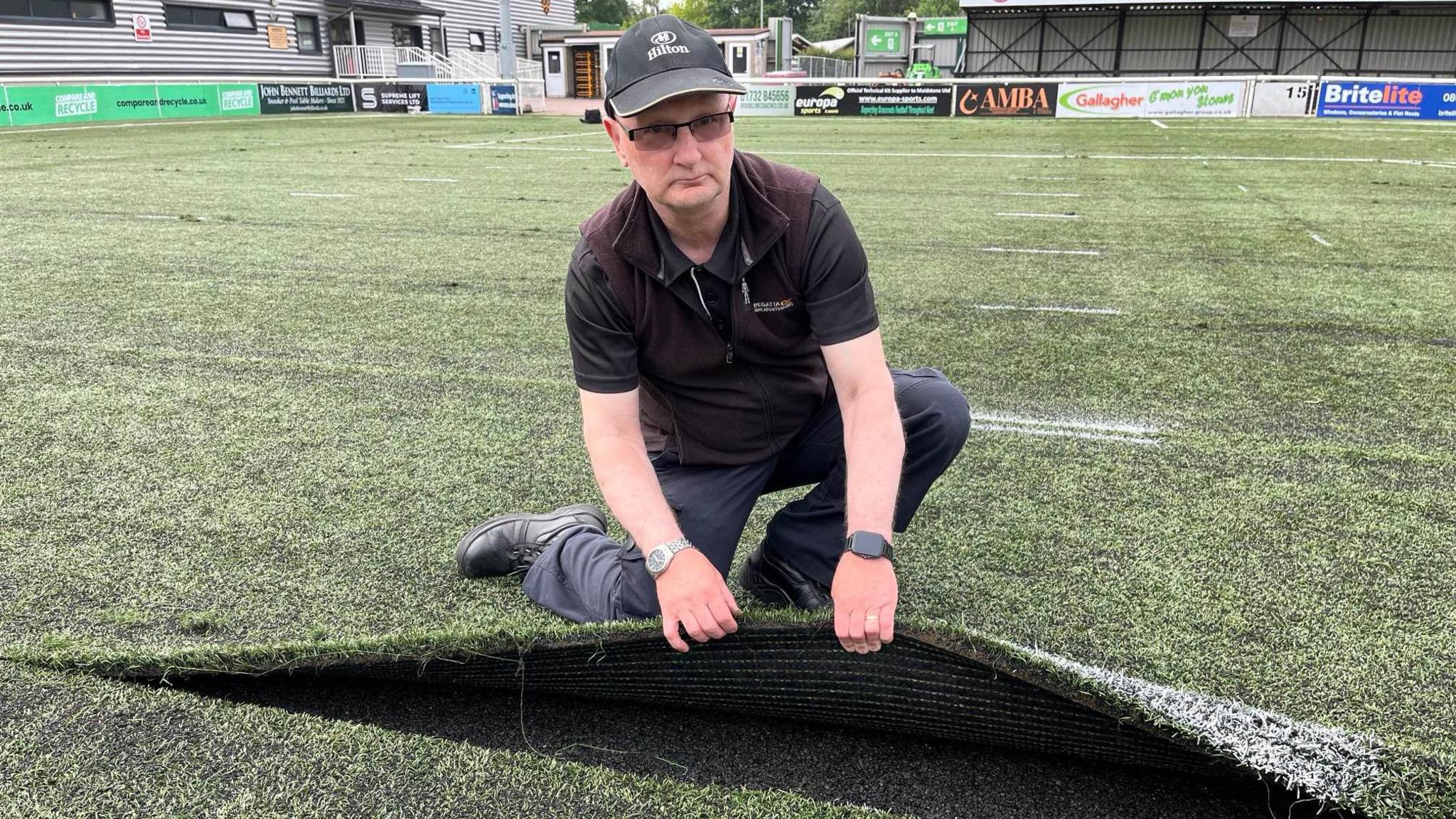 John Harvey lifts up the pitch at the Gallagher Stadium