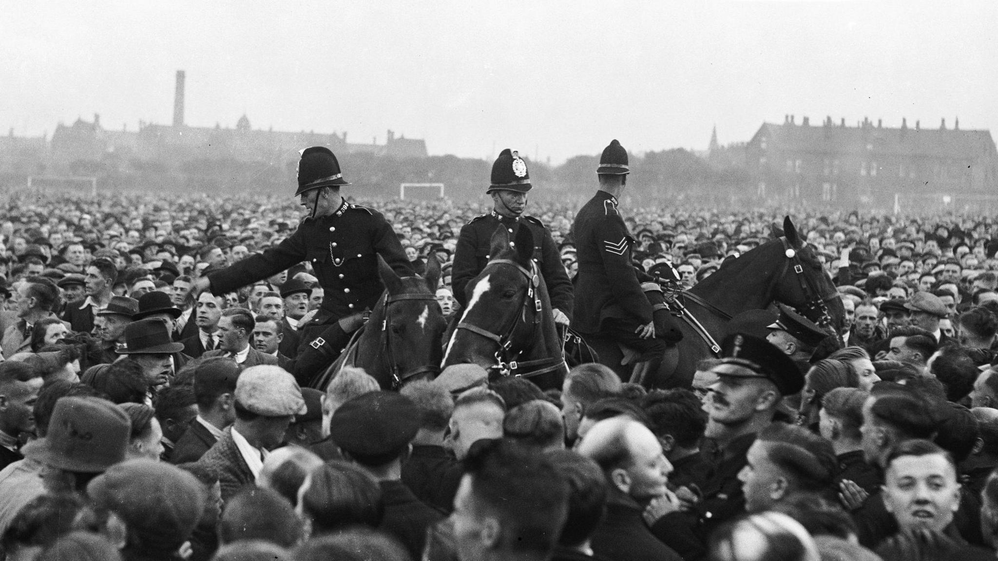 Historic black and white image of mounted police amongst the crowds at the Battle of Holbeck Moor in Leeds
