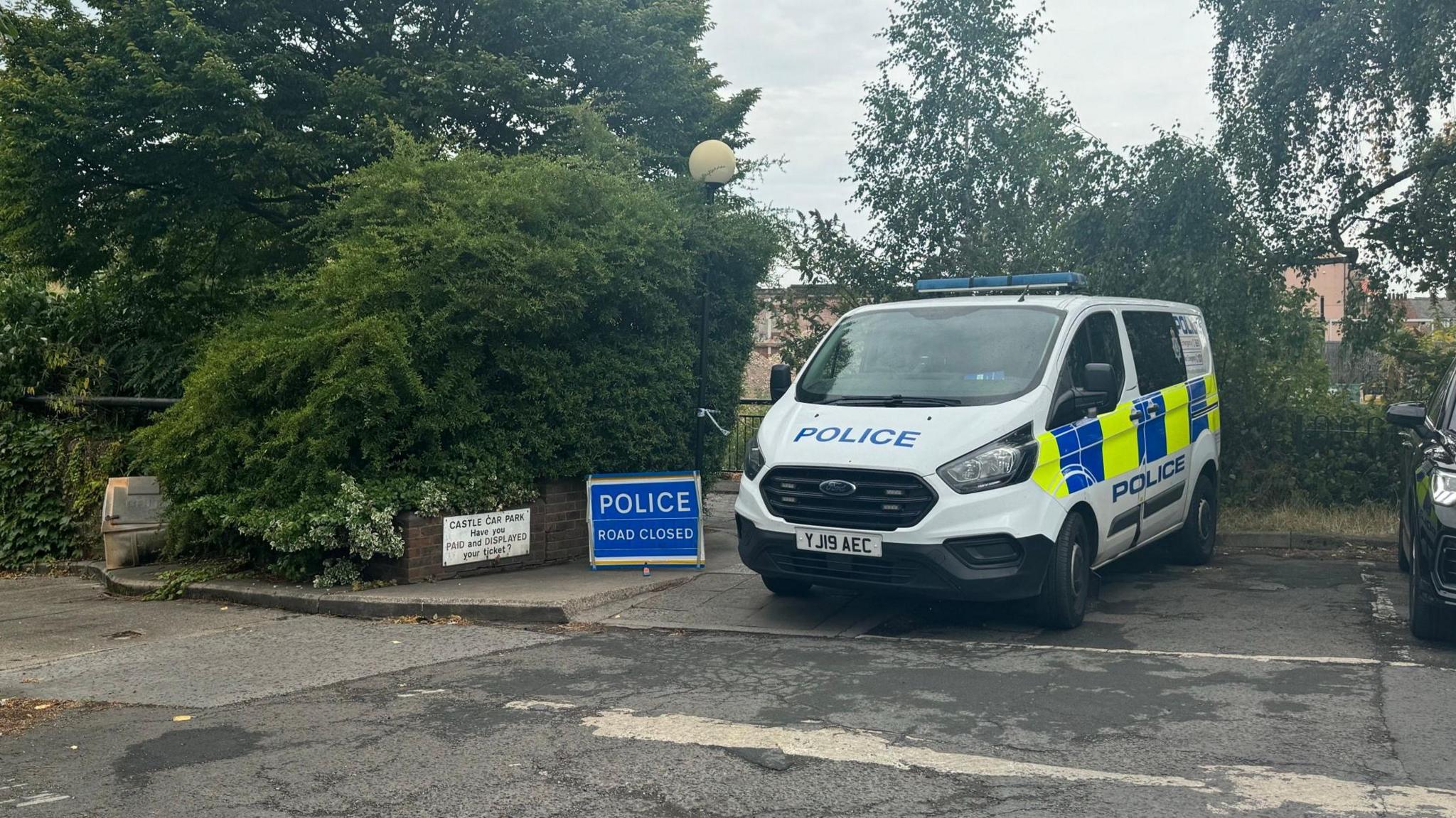 A police van and road closed sign at the cordon in Castle Car Park 