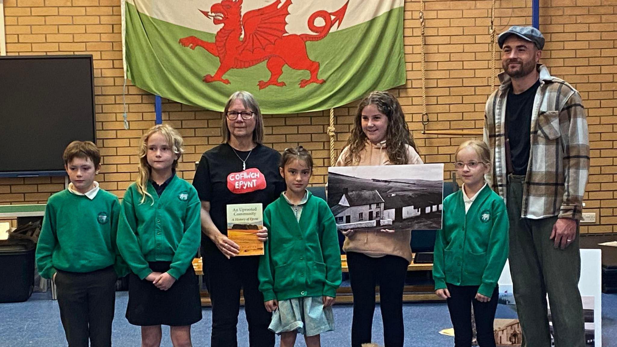 Dyma ni yn Ysgol Llanfair ym Muallt, gydag Ydwena, merch Iorwerth Davies, a rhai o ddisgynyddion Gwybedog ymhlith y gynulleidfa