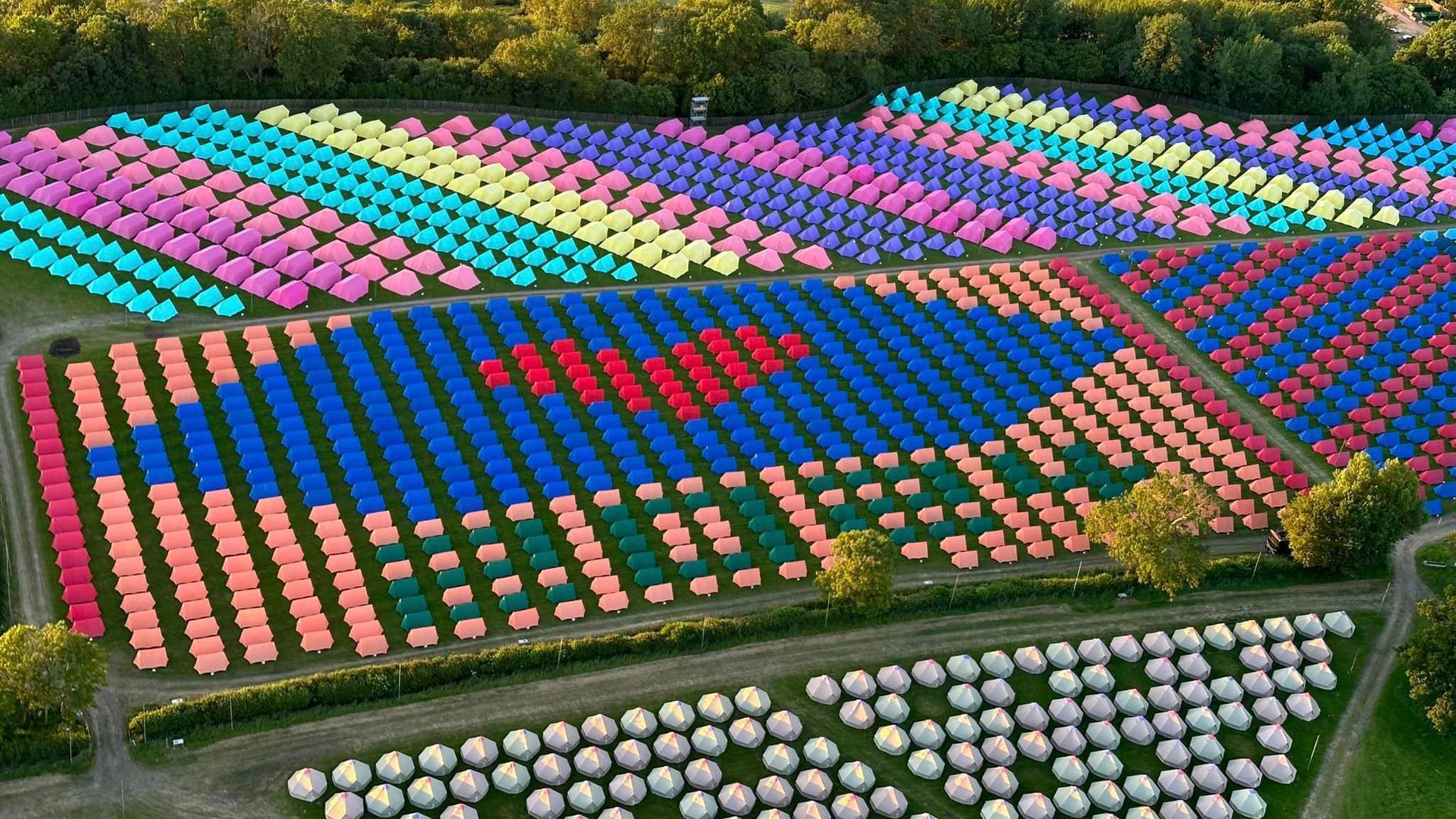 Aerial view of Worthy Farm in Somerset. Colourful tents have been organised to spell out 2024 and a heart icon