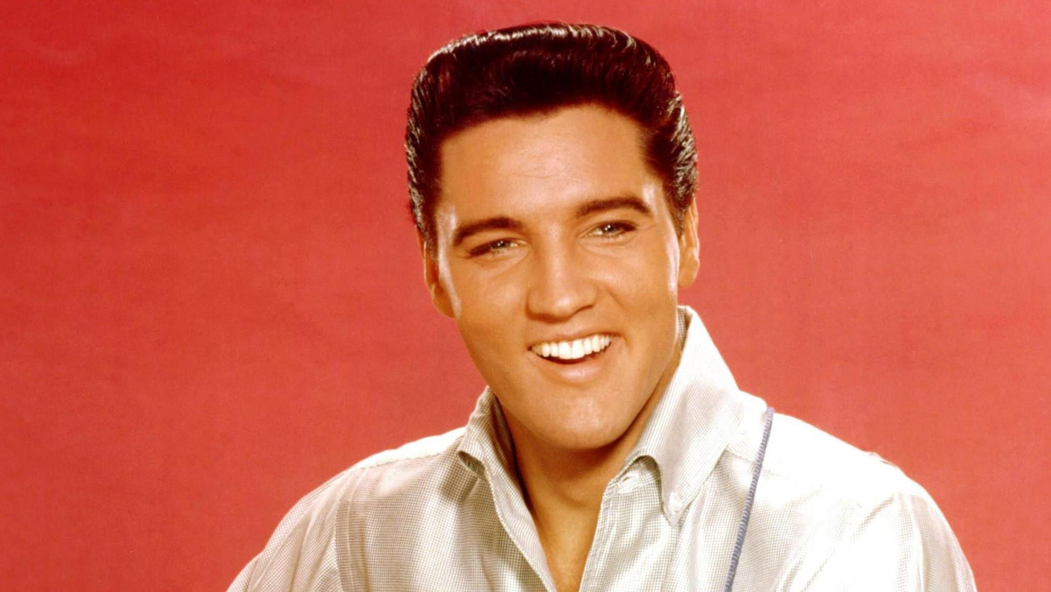 Elvis Presley strums an acoustic guitar while posing for a portrait in September 1962 in Culver City, California at MGM Studios