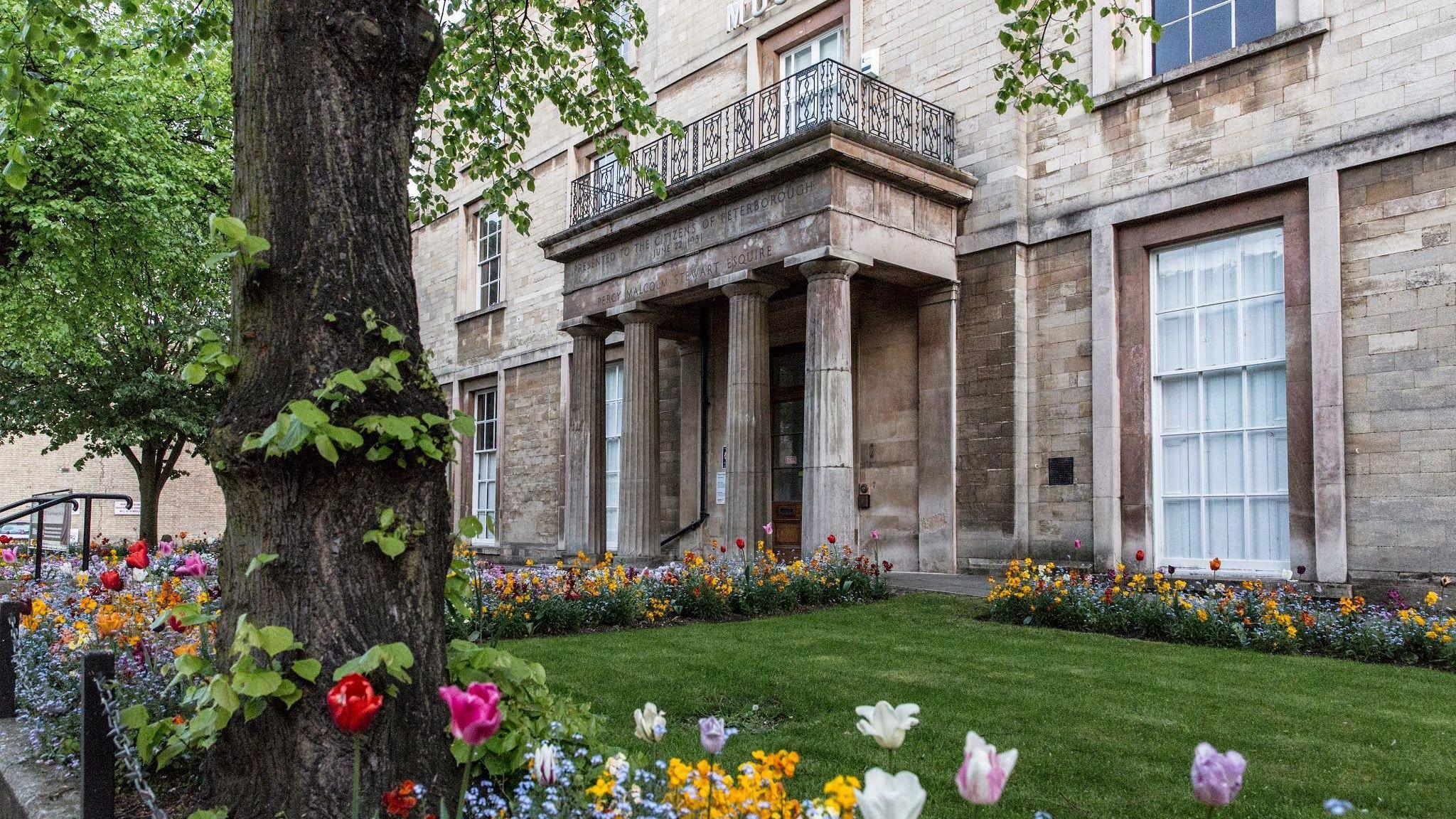 An exterior shot of the museum - with a small garden and flowers in the front of the building.