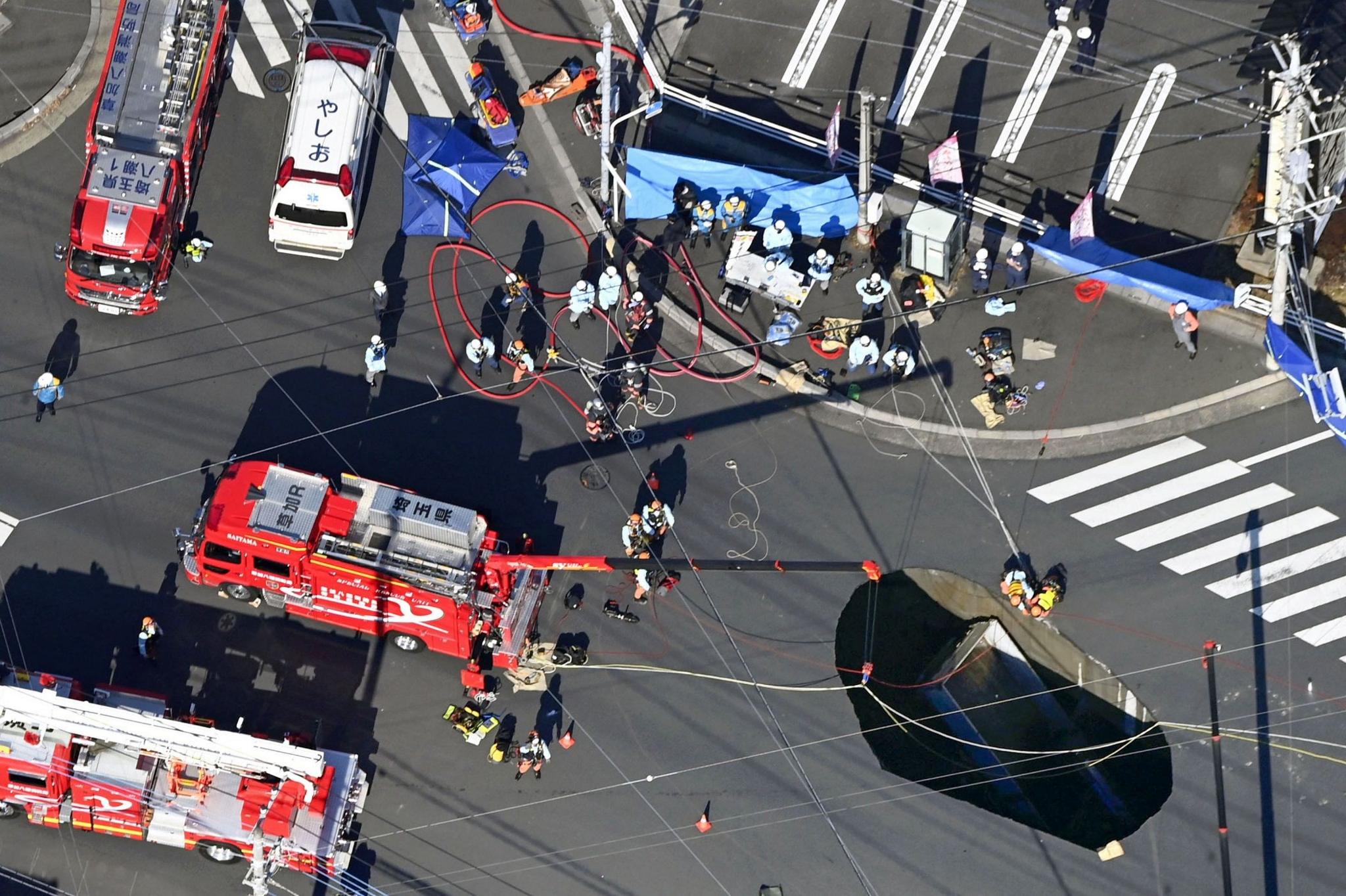 An aerial view shows rescue operations underway at a large sinkhole that swallowed a truck at an intersection in Yashio, north of Tokyo, Japan January 28, 2025