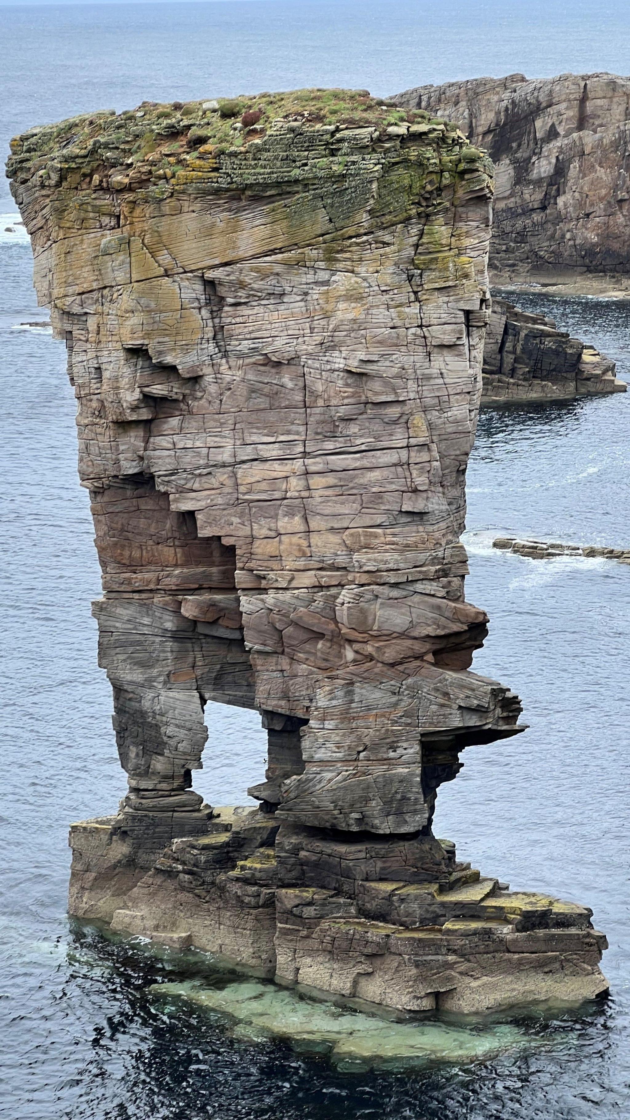 A pillar of rock surrounded by the sea.