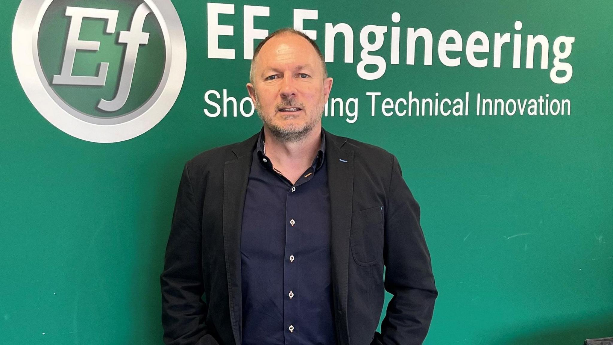 John Knight in front of an EF Engineering sign