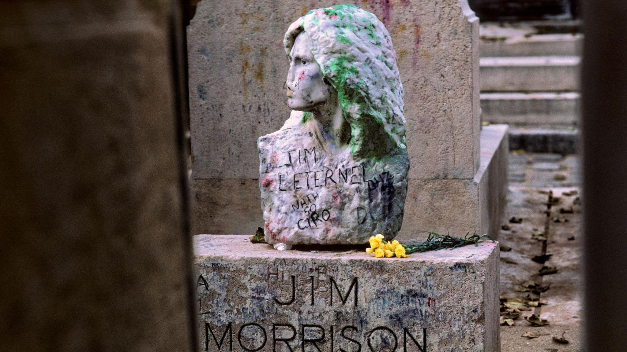 The bust of Jim Morrison, covered with graffiti, at his grave in Paris's famous Père-Lachaise cemetery