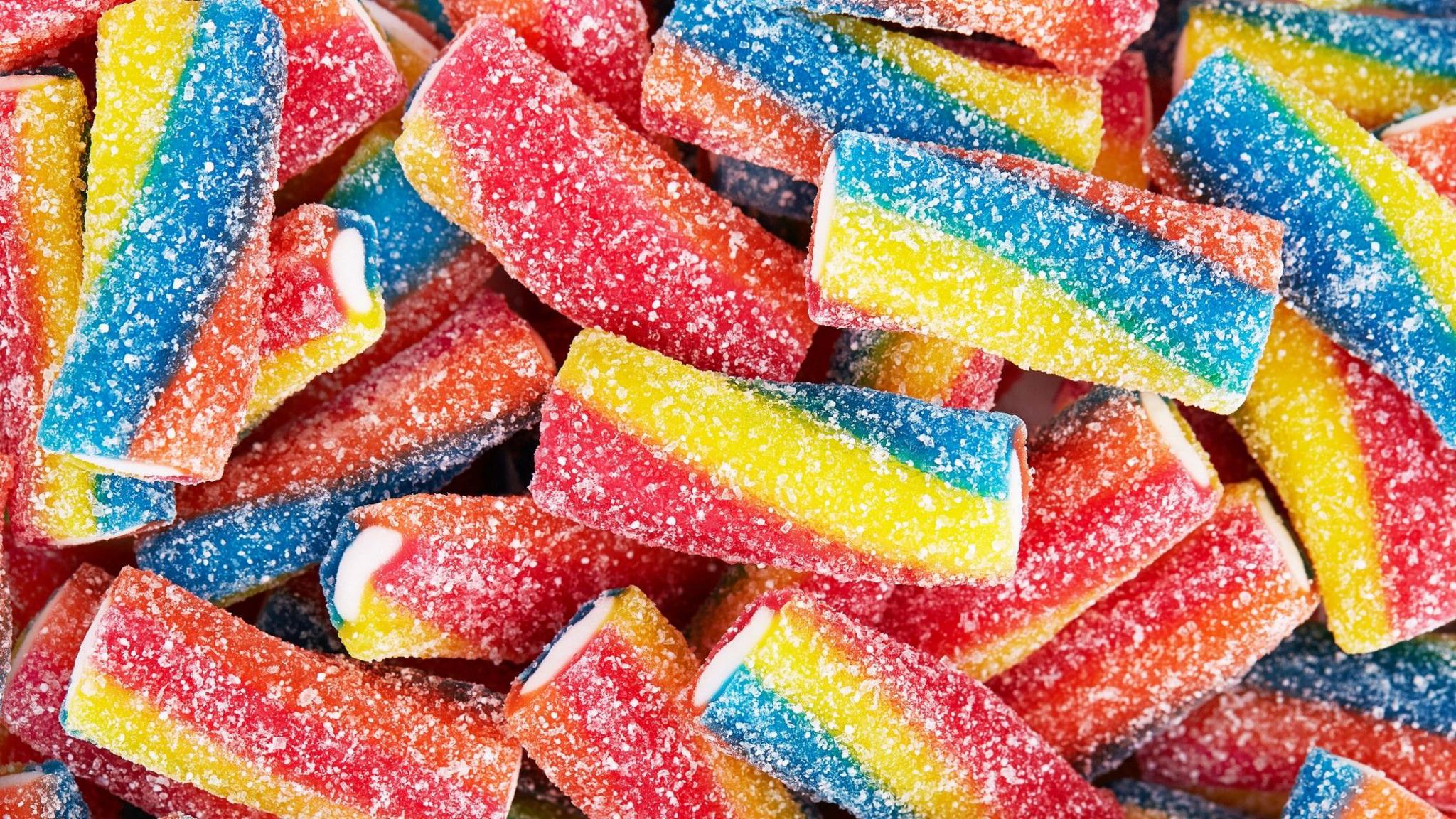 Rainbow sour jelly candy covered in sugar sprinkles