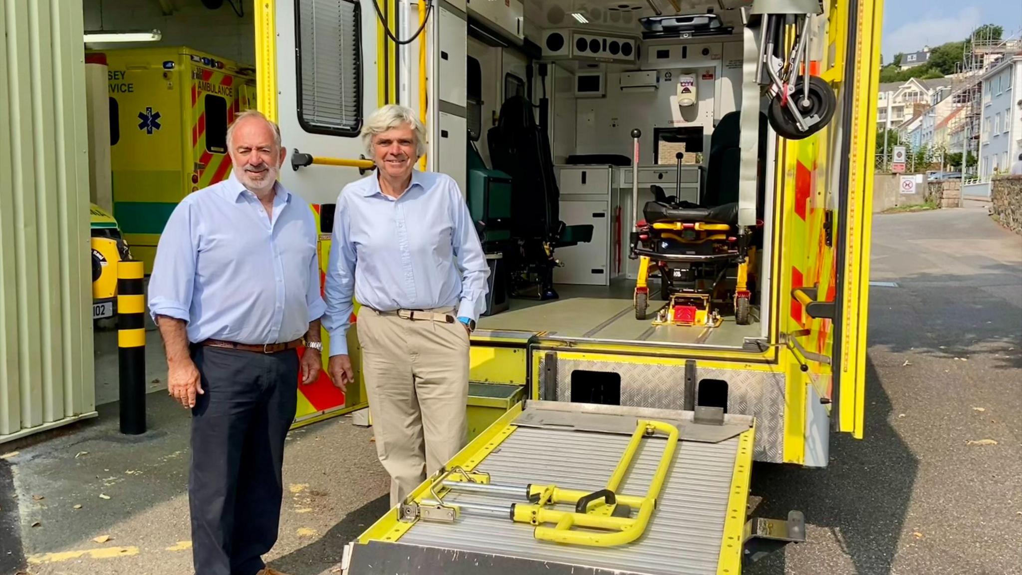 Bob De La Haye on the right and Dr Rhys Perkins on the left stand in front of an ambulance.            