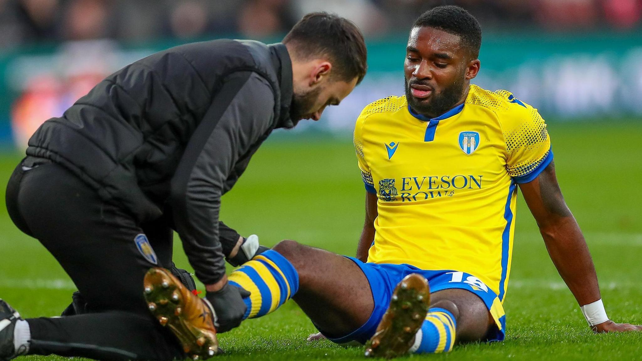 Colchester defender Mandela Egbo receiving treatment at MK Dons last season