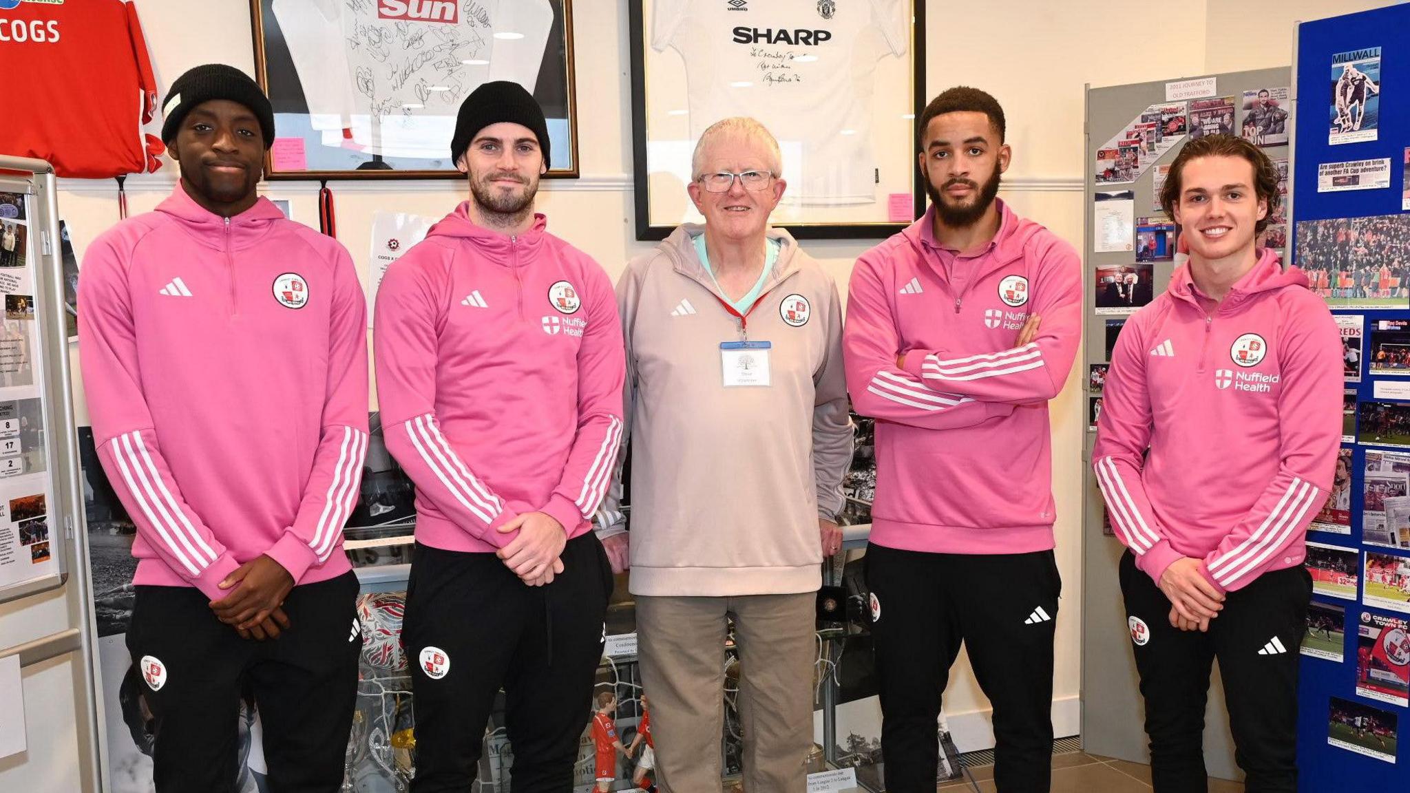 Steve Leake stands with four Crawley Town players in the club's museum 