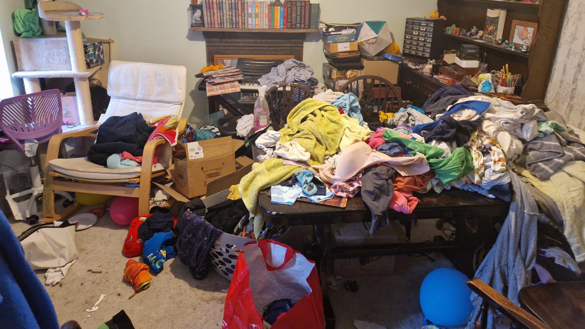 A room full of clutter, clothes and items