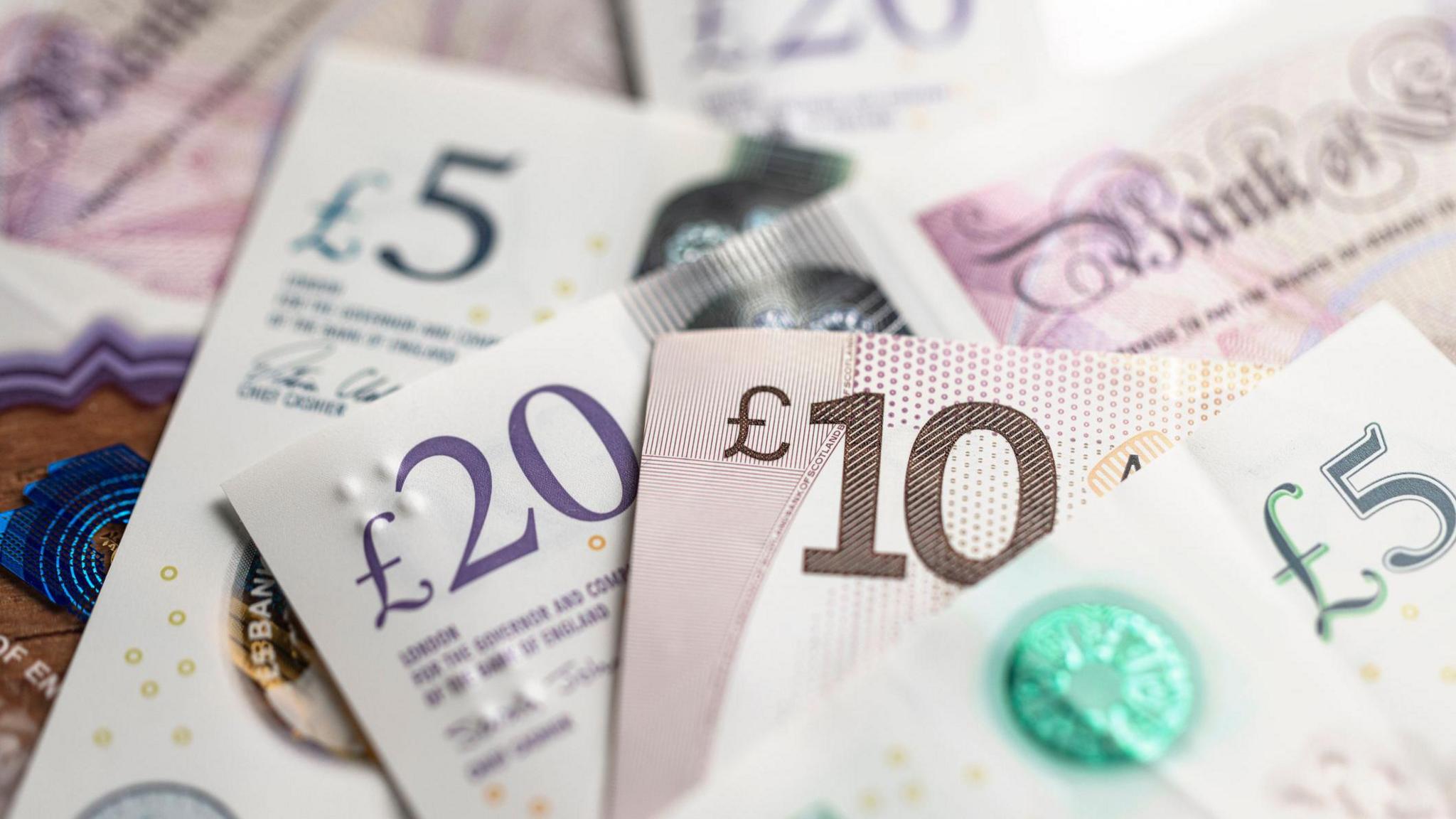 Selection of banknotes including £5, £10 and £20 notes.
